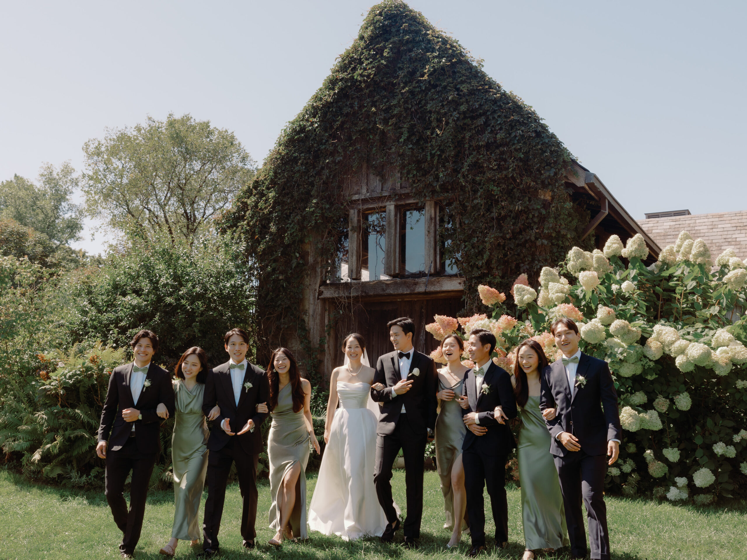 The newlyweds, together with their bridesmaids and groomsmen are having fun posing for photos. Photojournalistic wedding photography image by Jenny Fu Studio