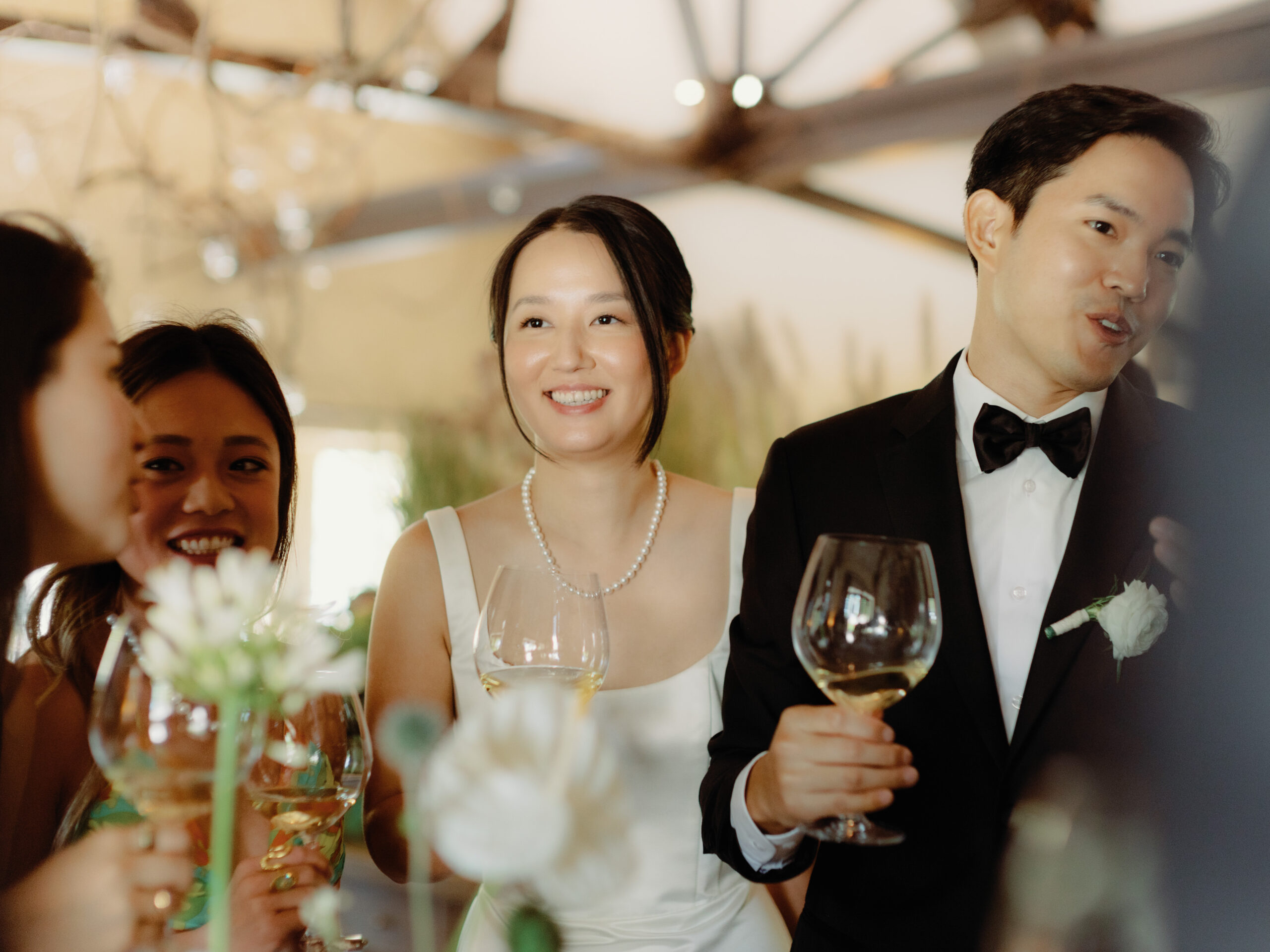 The newlyweds are chatting with guests in their wedding reception while drinking champagnes, candidly captured by Jenny Fu Studio.