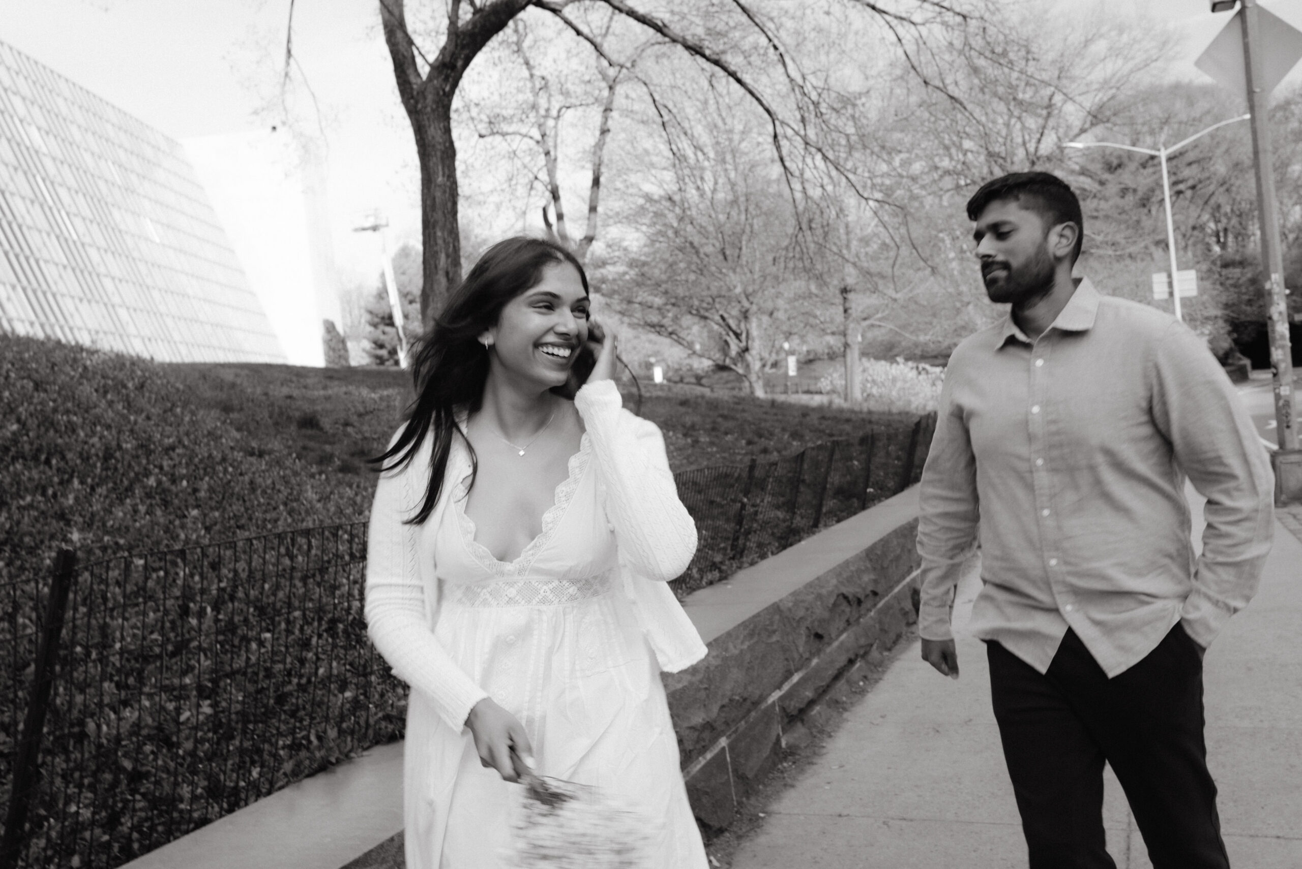 The engaged couple are happily walking in Central Park, NYC, candidly captured by Jenny Fu Studio