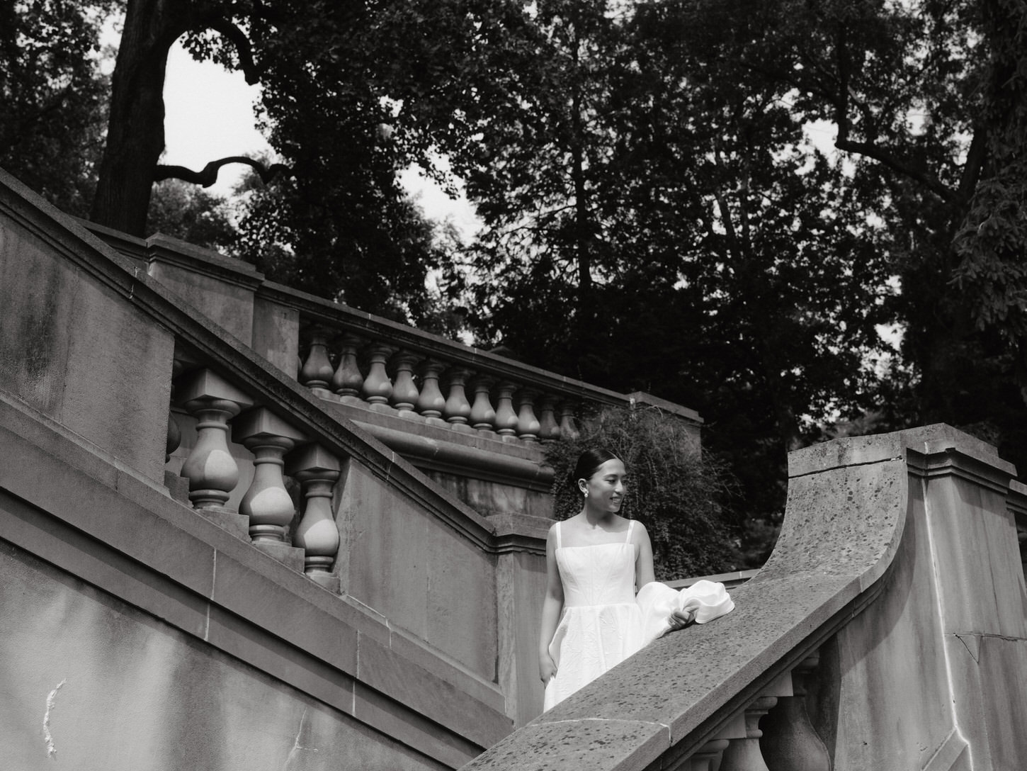 The excited bride is going down the staircase of a timeless structure, beautifully captured by Jenny Fu Studio.