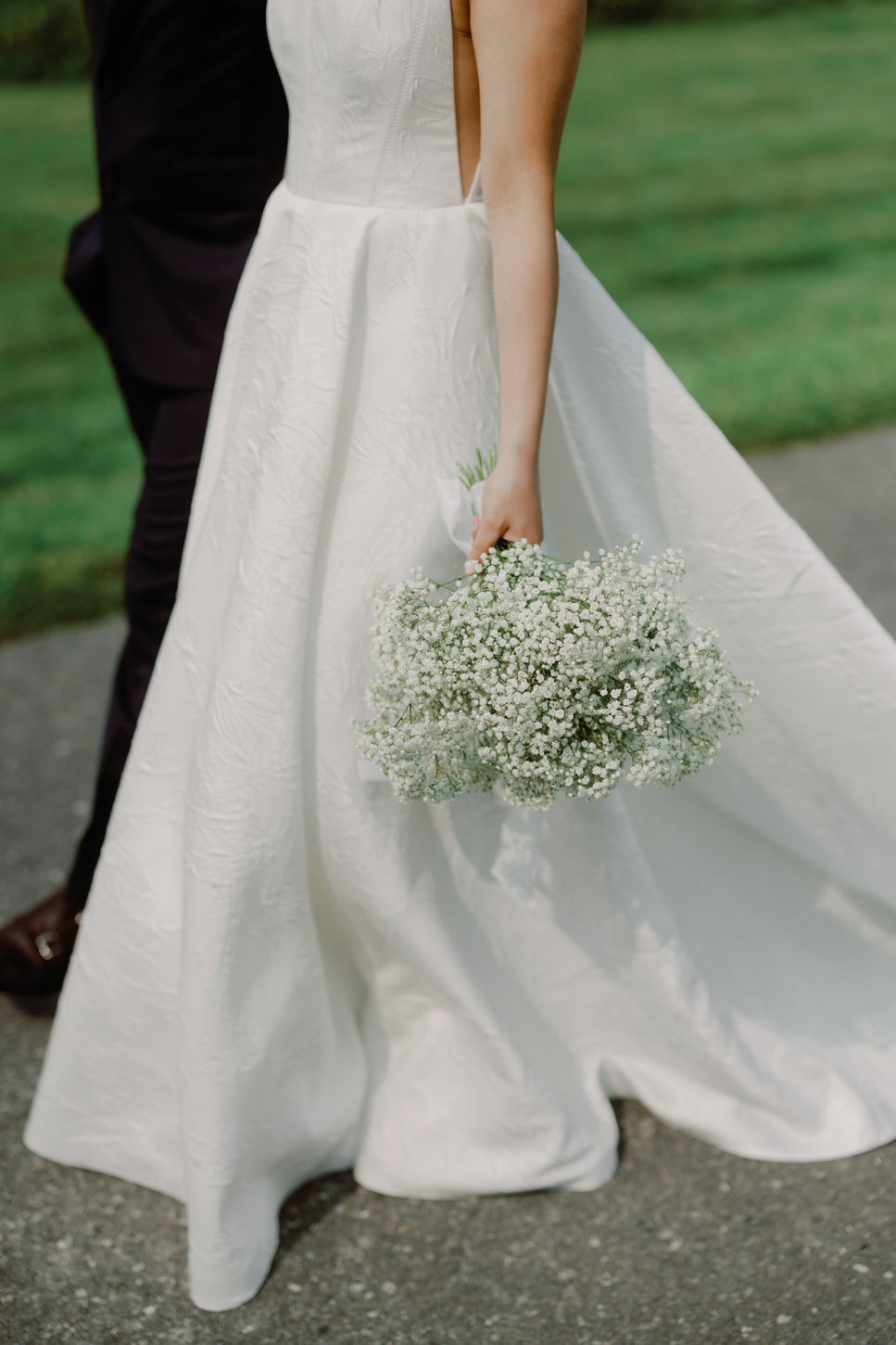 A photo of the bride focusing on her pretty wedding dress and flower bouquet, by Jenny Fu Studio.