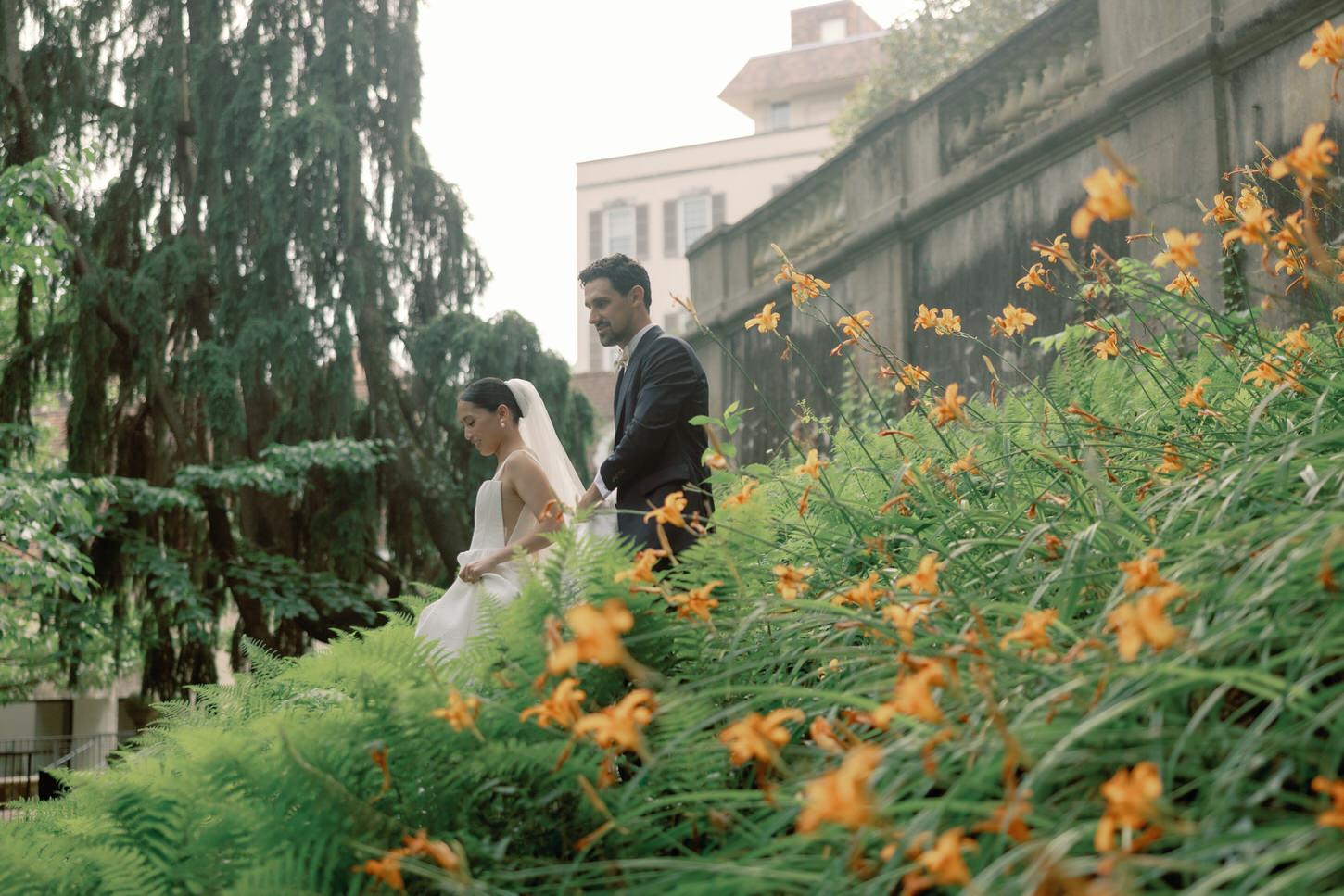 A candid shot of the bride and groom walking among flowers in a cinematic wedding photography by Jenny Fu Studio.