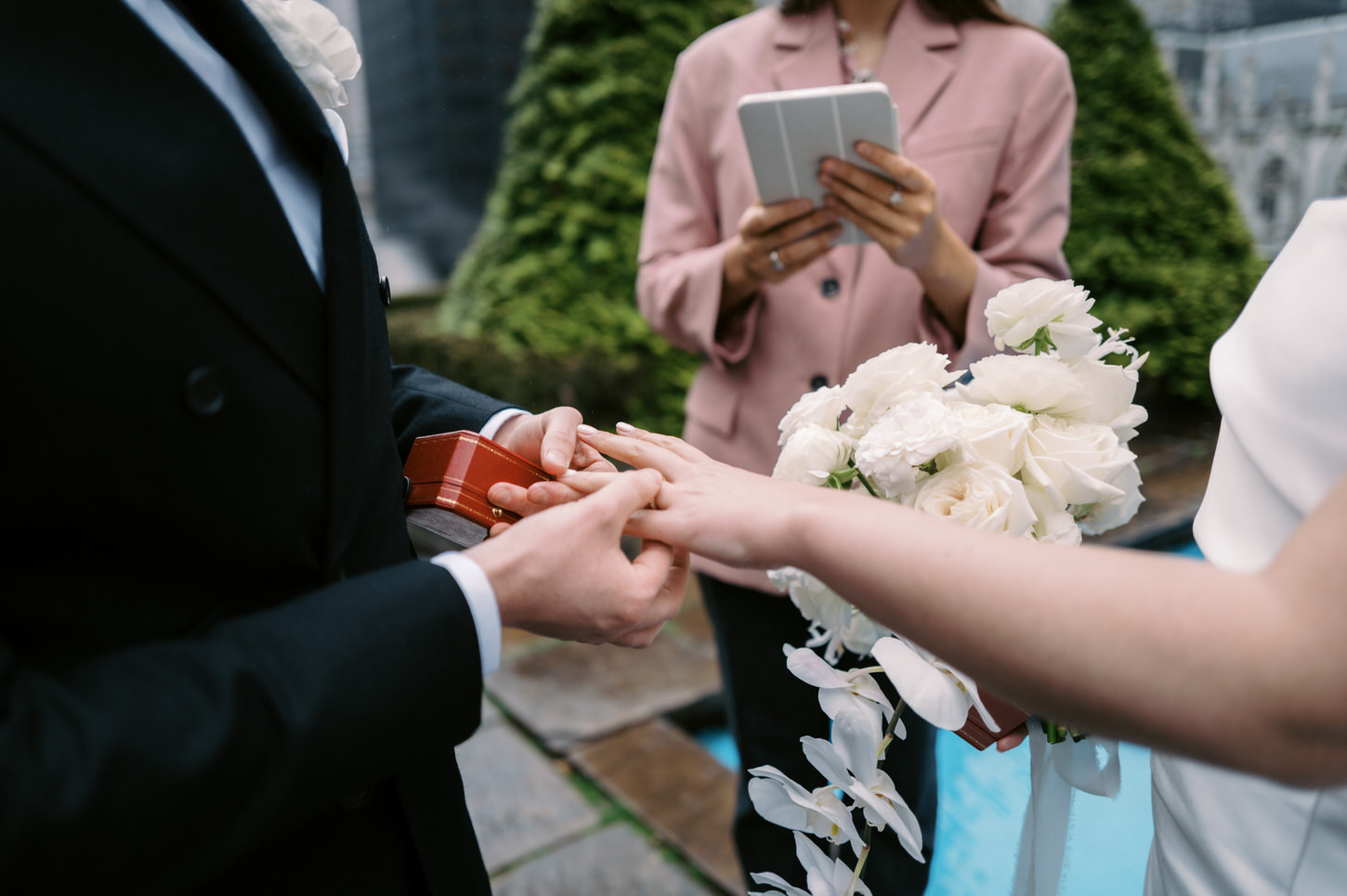 A photojournalistic image of the groom putting on the wedding band to her bride in the middle of their elopement in NYC, by Jenny Fu Studio