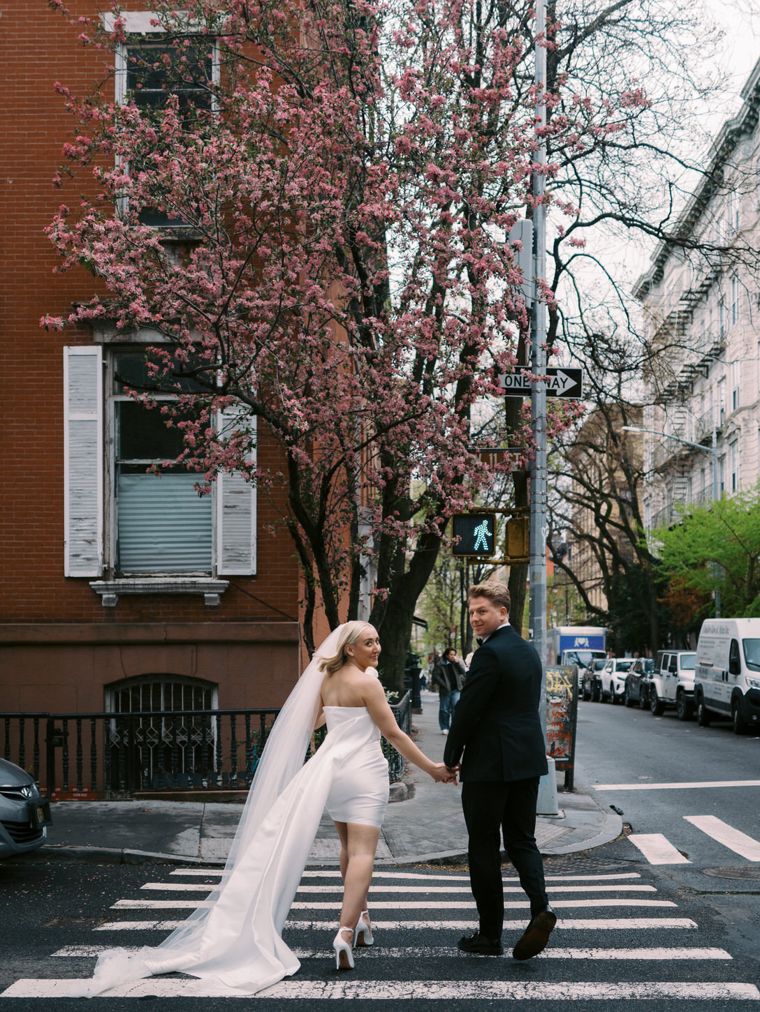 The newlyweds are crossing the streets of West Village after their elopement in NYC, candidly captured by Jenny Fu Studio.