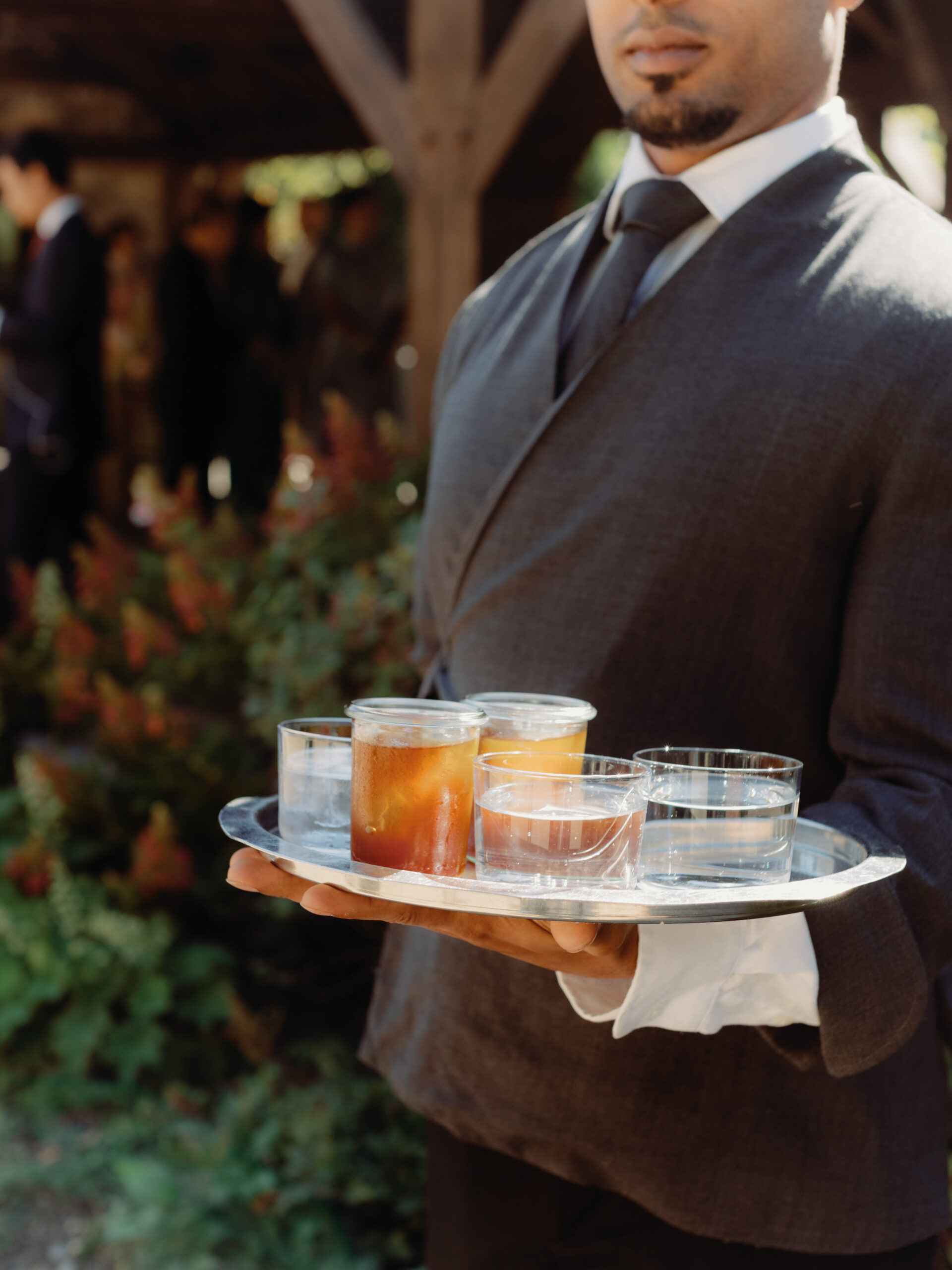 Photo of refreshments held by a waiter at an outdoor wedding in New York, candid shot by Jenny Fu Studio.