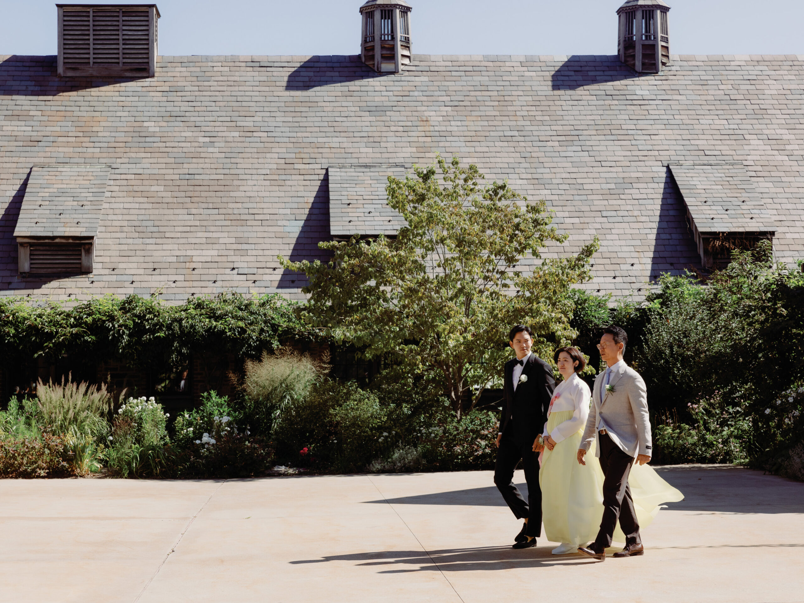 The groom is excitedly walking towards the aisle accompanied by his parents, candidly captured by Jenny Fu Studio.