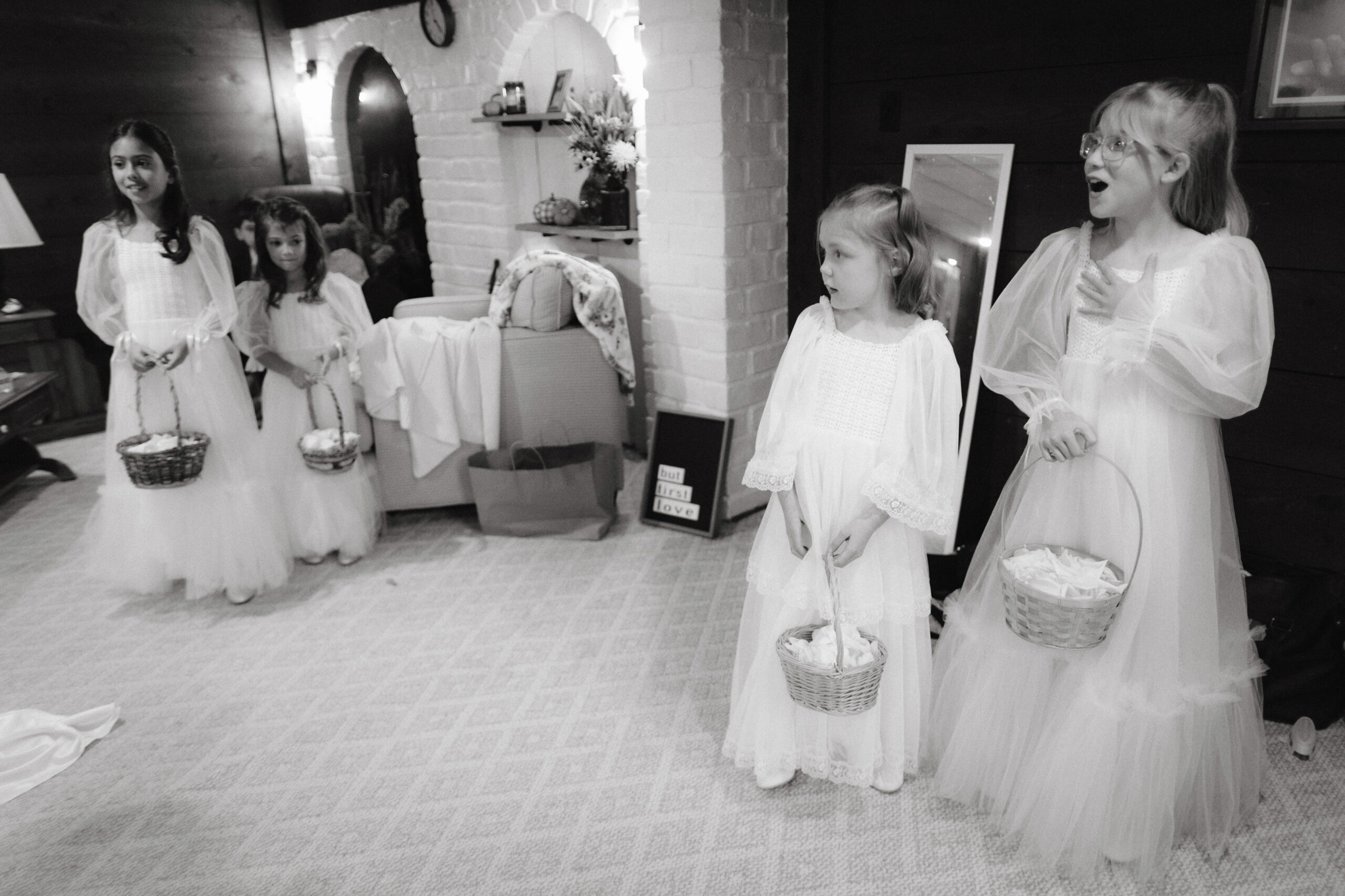 Black and white photojournalistic image of the flower girls, looking at the bride, all amazed, captured by Jenny Fu Studio