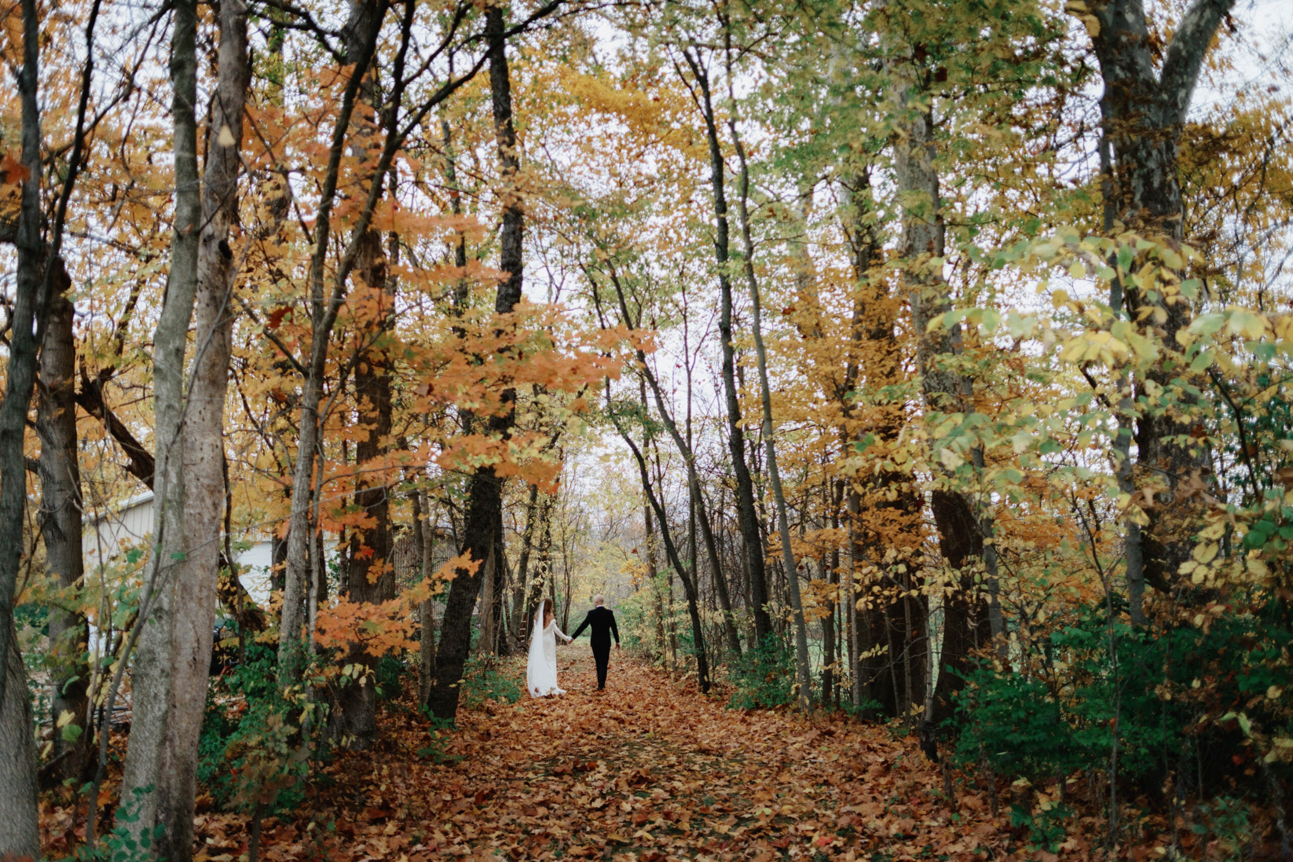 The newlyweds walks hand in hand amidst the beauty of fall foliage, wonderfully captured by Jenny Fu Studio.