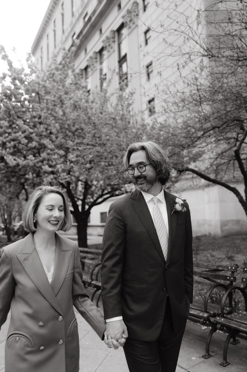 Black and white photo of the newlyweds walking in the wedding garden after their NYC City Hall elopement, shot by Jenny Fu Studio.