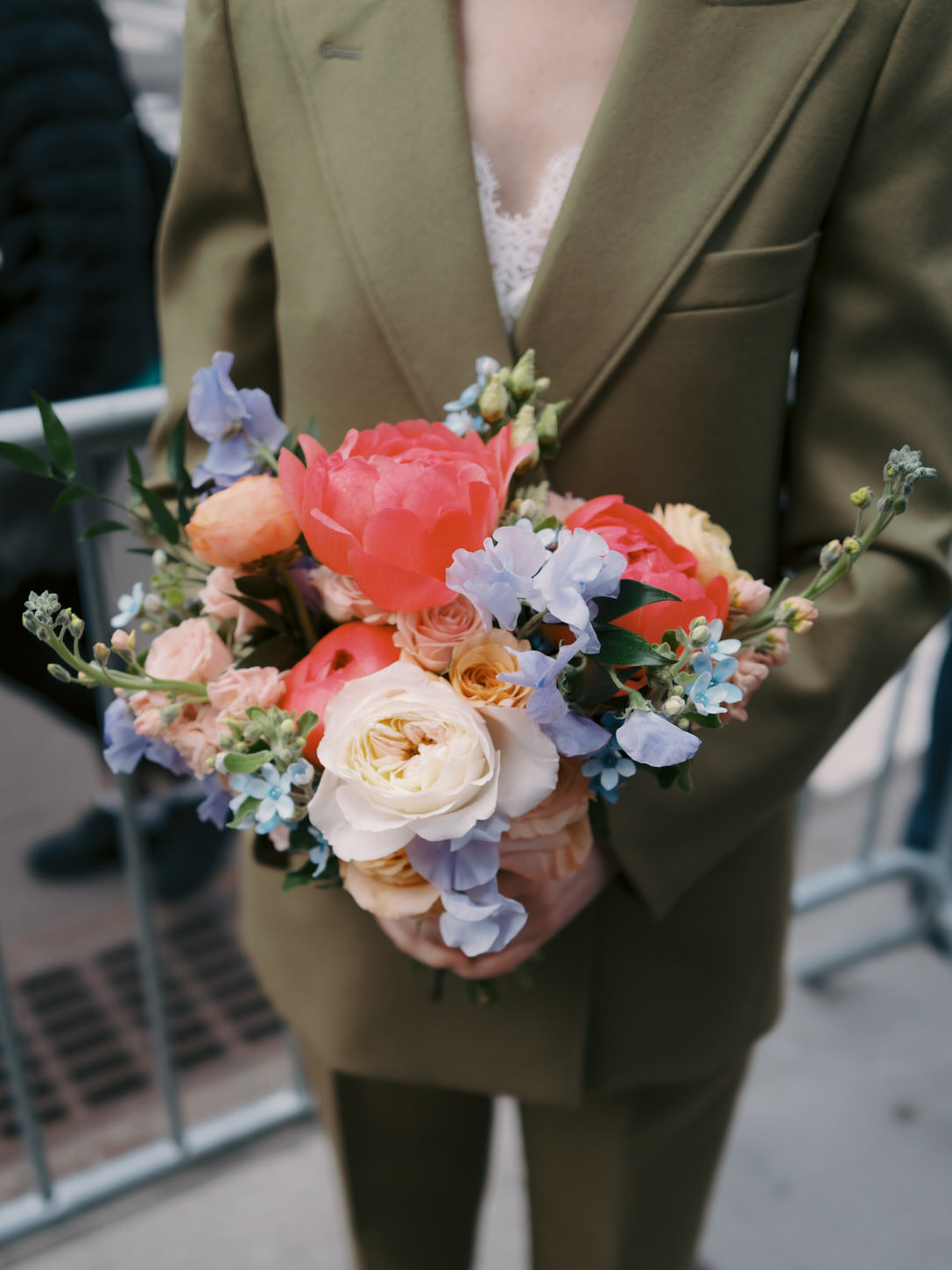 Beautiful spring flowers in colors of peach, white and lilac for a wedding bouquet held by the bride.