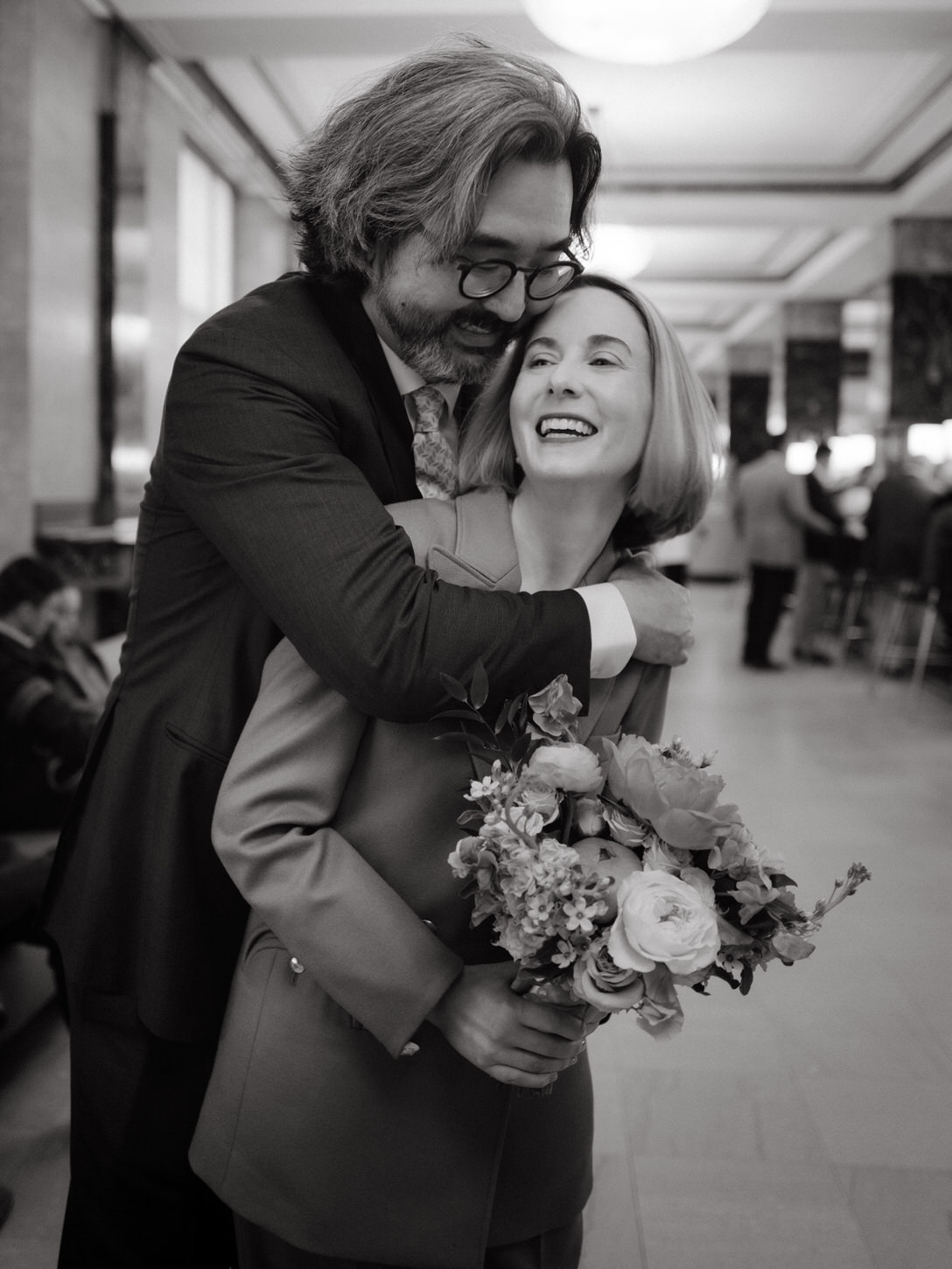 Black and white happy image of the bride and groom inside NYC City Hall for their elopement captured by Jenny Fu Studio.