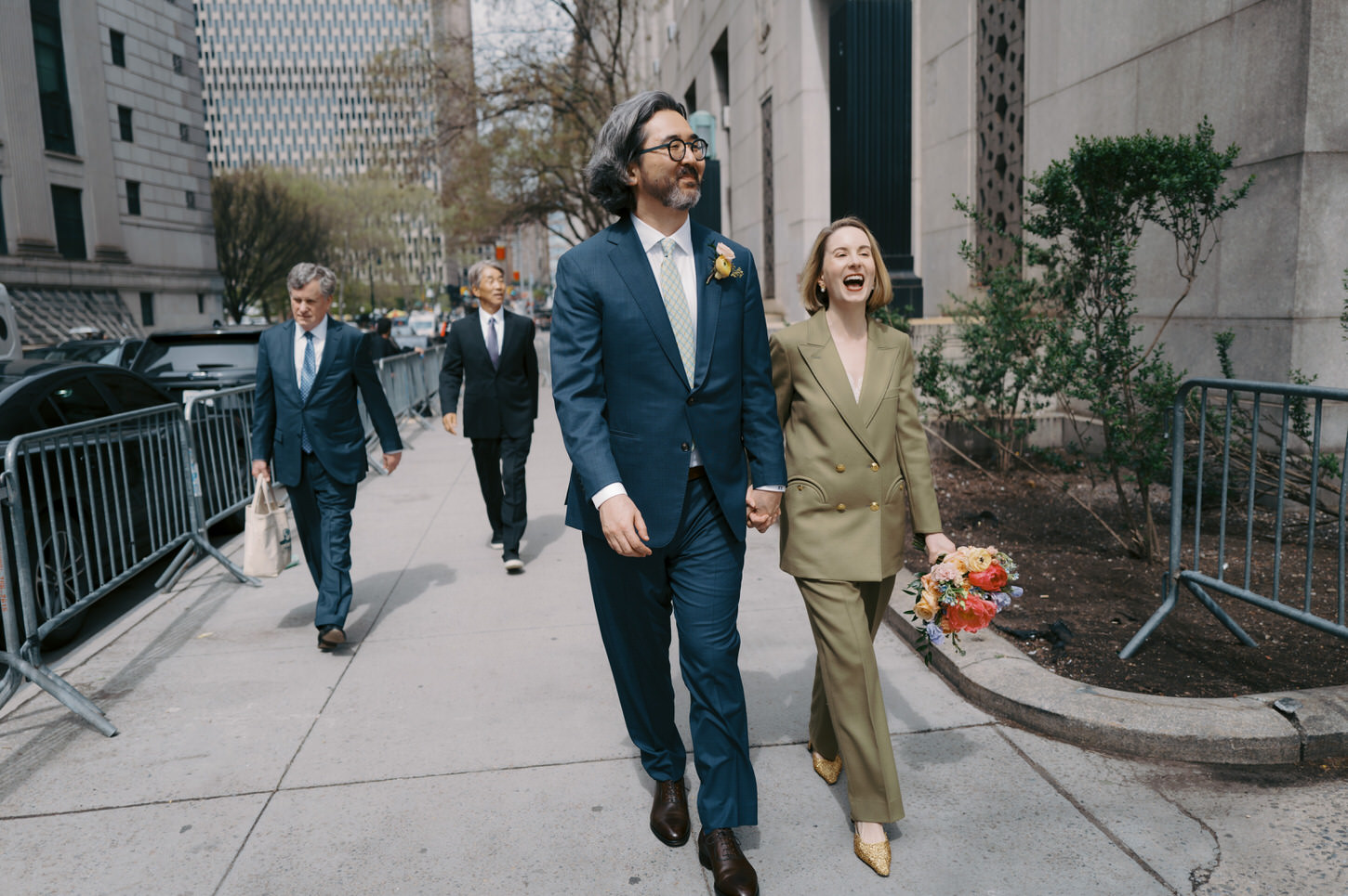 The newlyweds are happily walking towards the subway after their spring wedding at NYC City Hall, shot by Jenny Fu Studio.