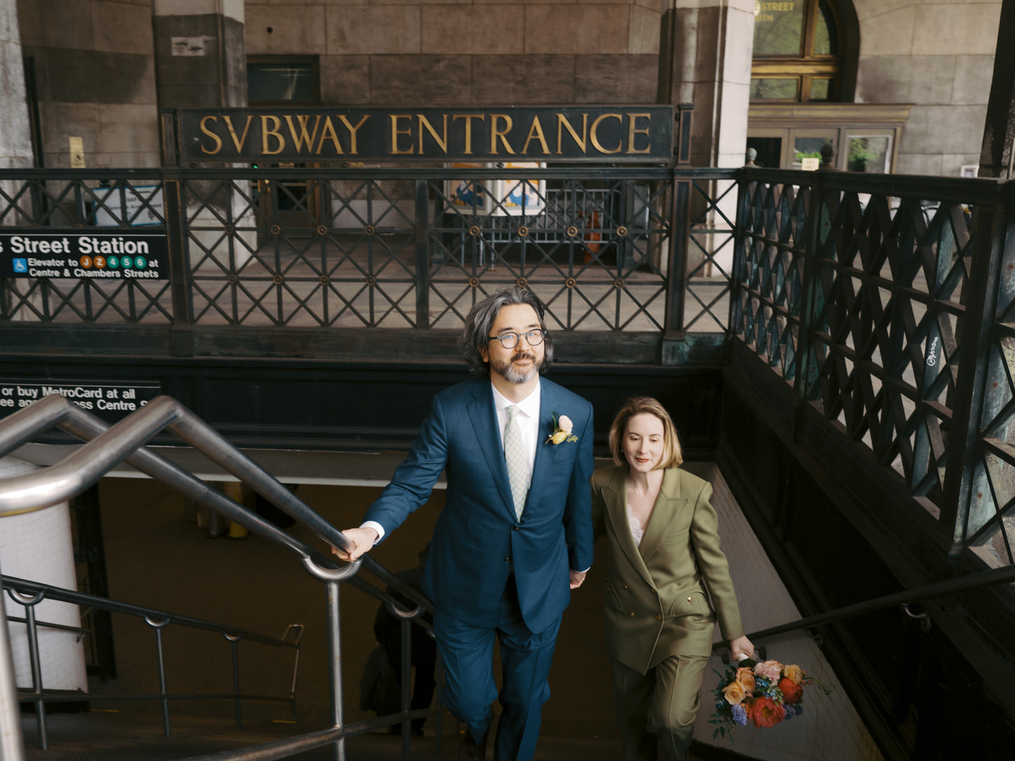 The newlyweds are climbing up the staircase in the subway, candidly shot by Jenny Fu Studio. 