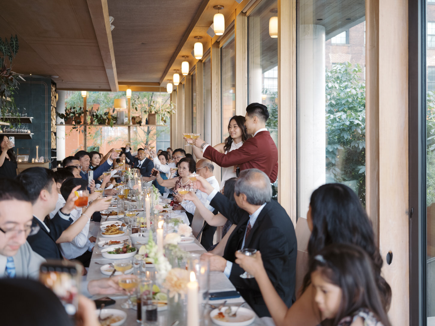 The bride and groom toasts with the guests in their wedding reception at Brooklyn, NYC, a candid elopement shot by Jenny Fu Studio.