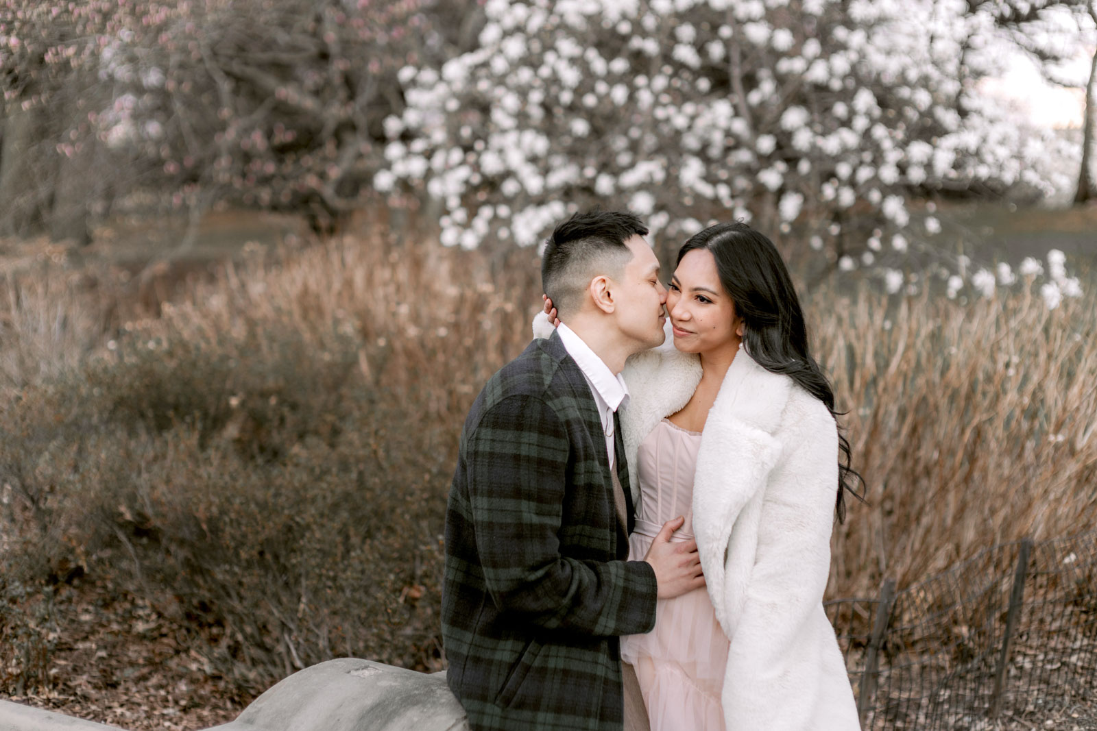 The engaged couple are having a romantic moment at Central Park, NYC, candidly captured by Jenny Fu Studio in a pre-wedding session.