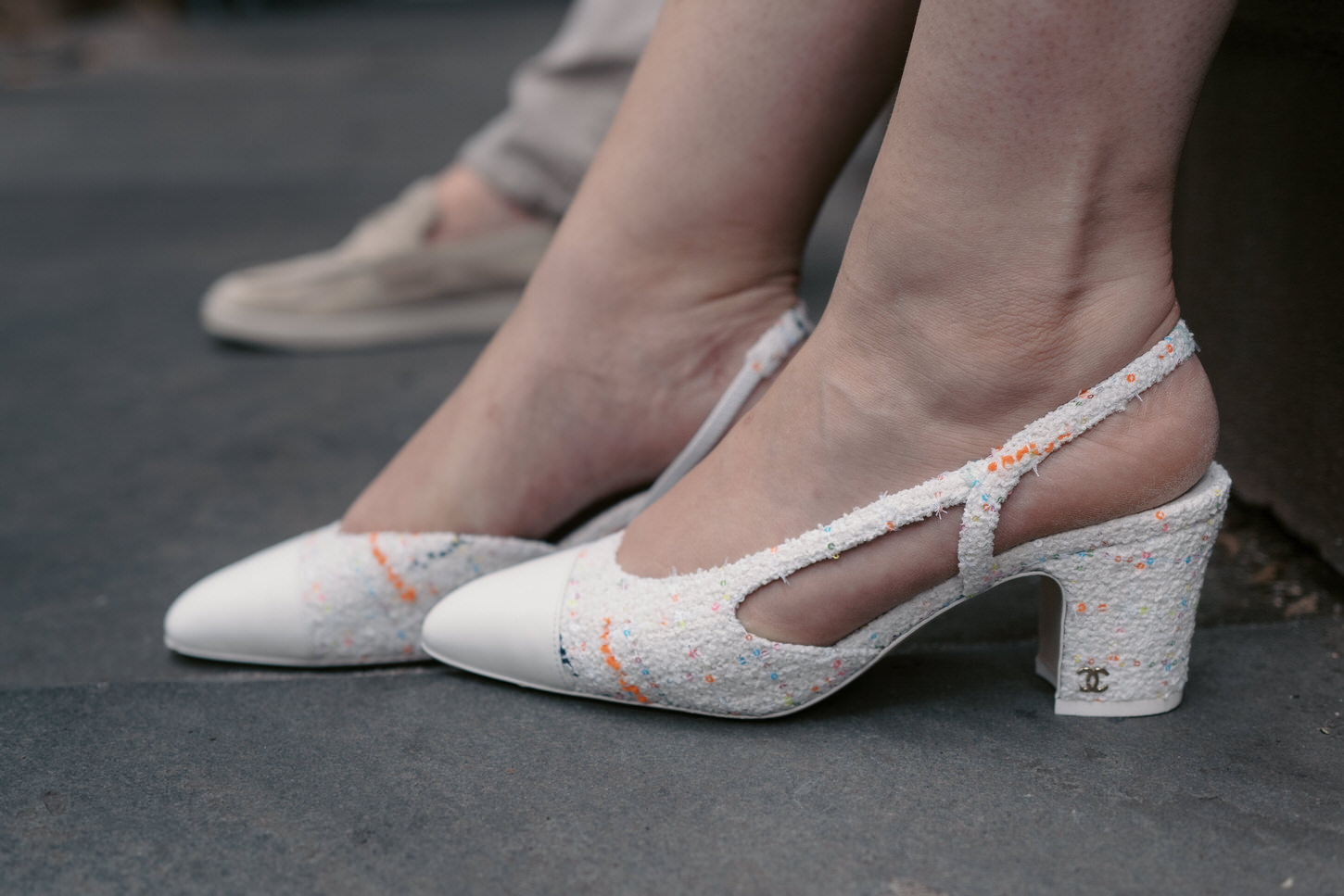 A close up photo of the  fiancée's feet, wearing a Chanel footwear in their engagement photo captured by Jenny Fu Studio.