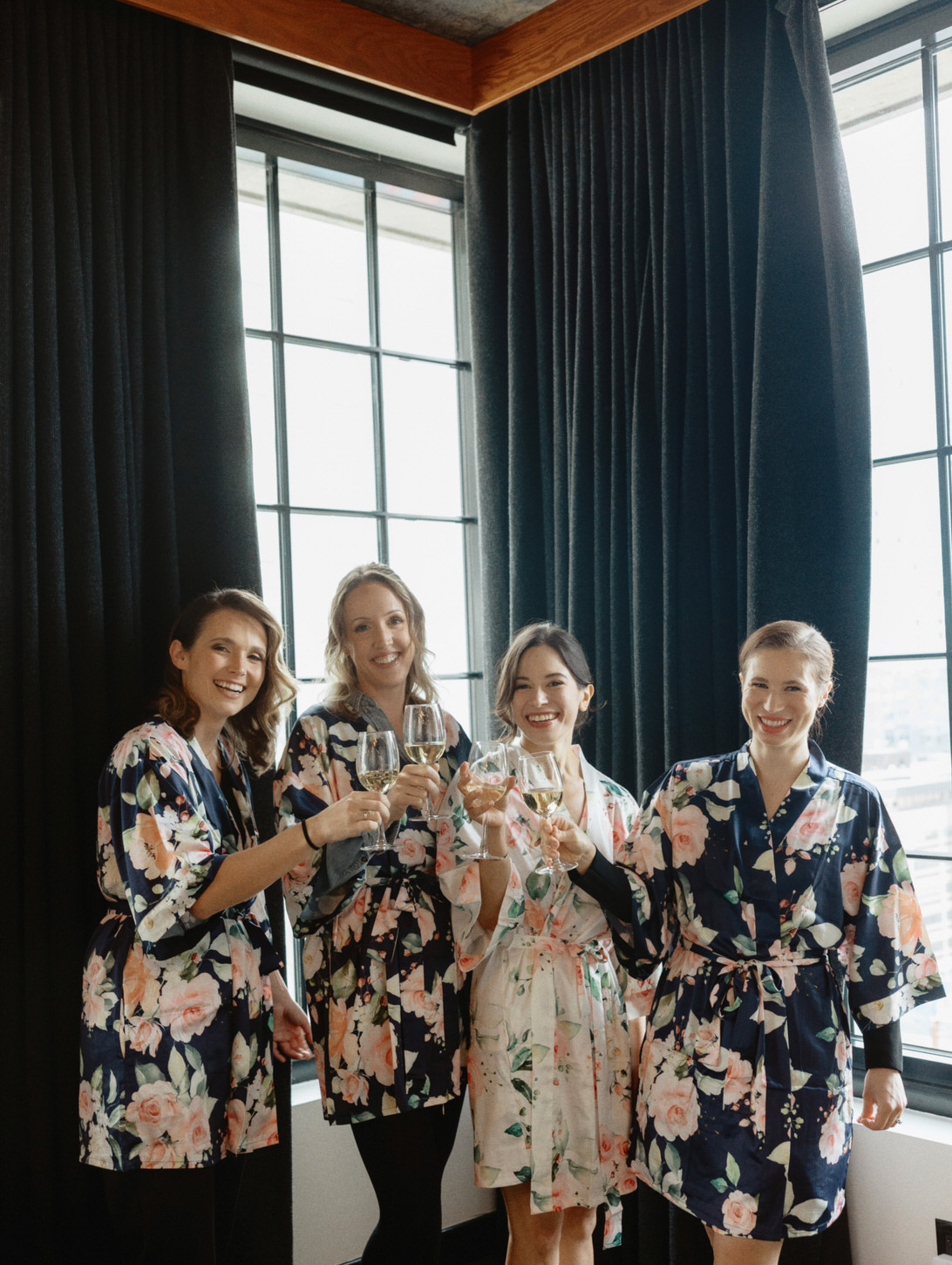 The bride and bridesmaids happily share a toast while getting ready for the wedding, shot by Jenny Fu Studio.