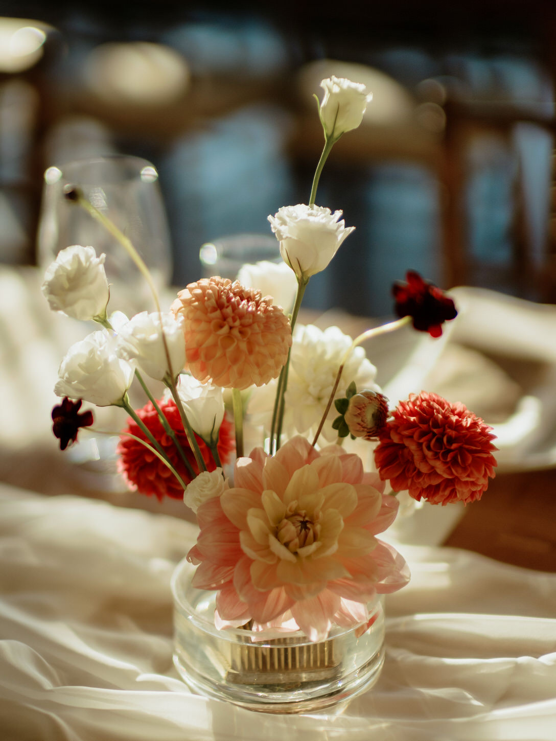 A wedding reception table centerpiece filled with a variety of special flowers captured by Jenny Fu Studio.