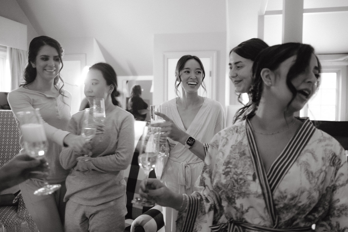 The bride and bridesmaids are happily having a toast while getting ready, in a wedding album image captured by Jenny Fu Studio.