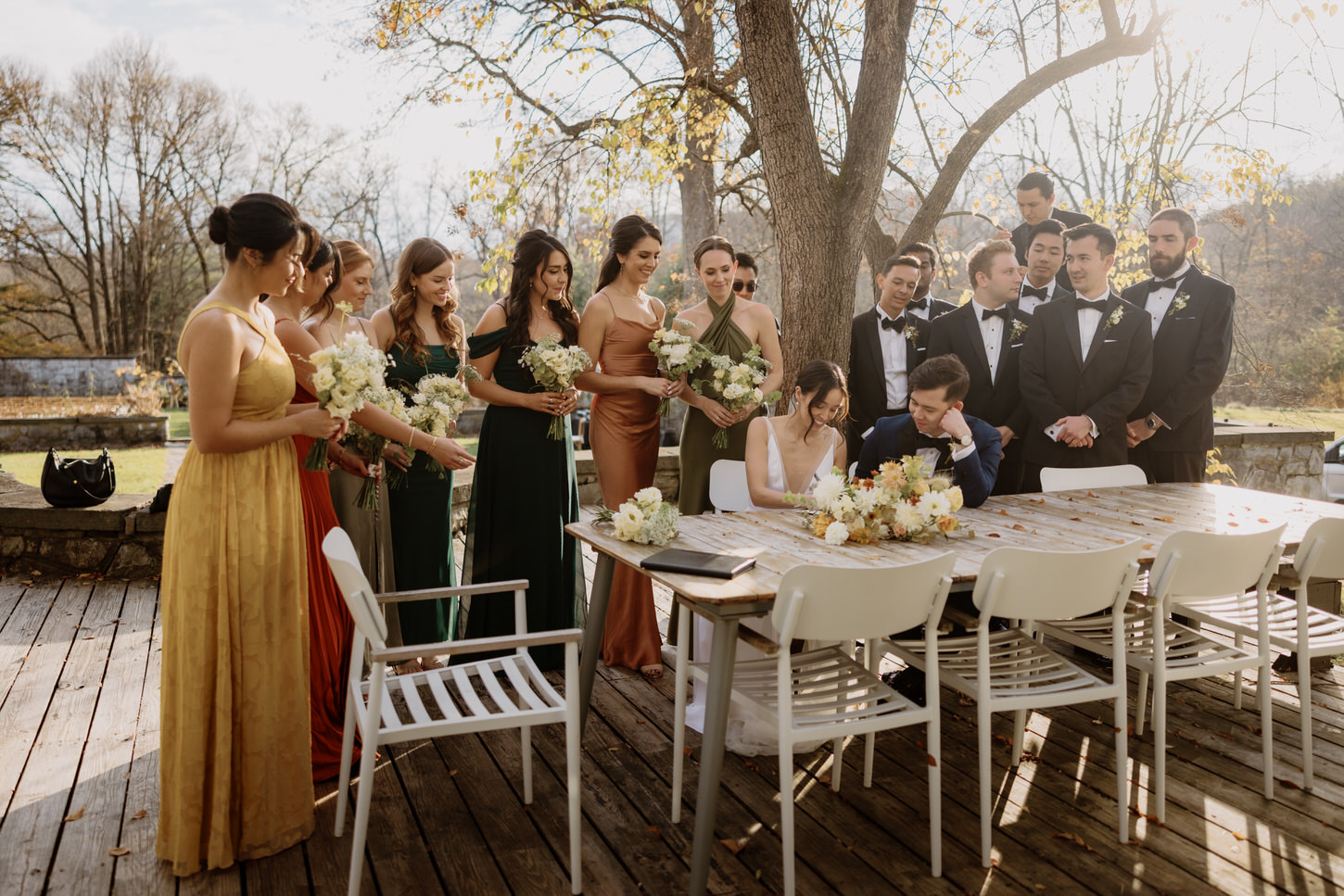 The bride and groom are signing a document as the bridesmaids and groomsmen look on, candidly captured by Jenny Fu Studio.