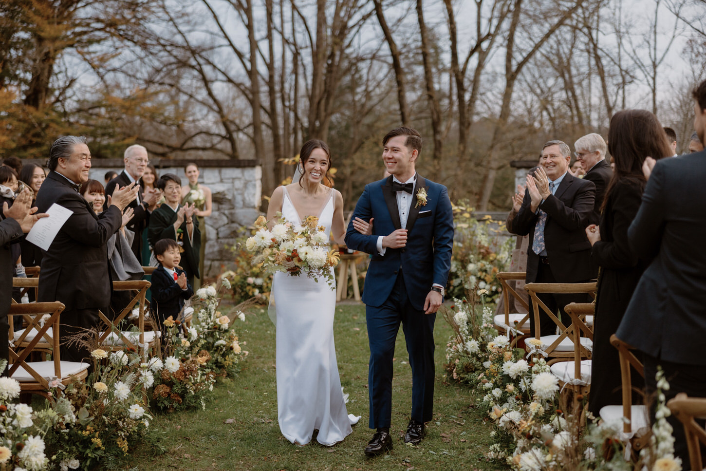 The newlyweds walk back the aisle with a smile on their faces as the guests cheer on, captured by Jenny Fu Studio.