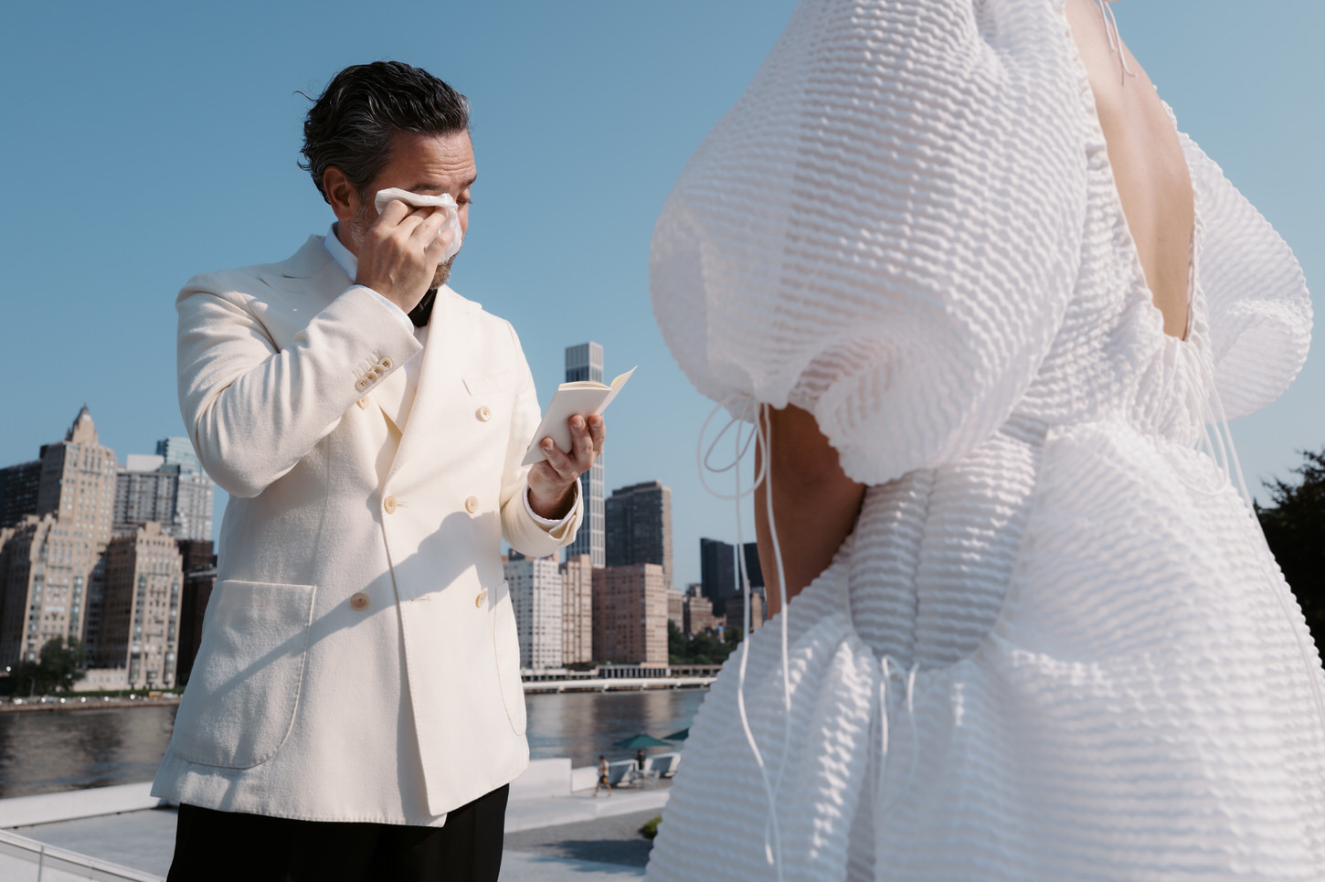 The groom is wiping his tears as he emotionally reads his vows to his bride, captured by Jenny Fu Studio.