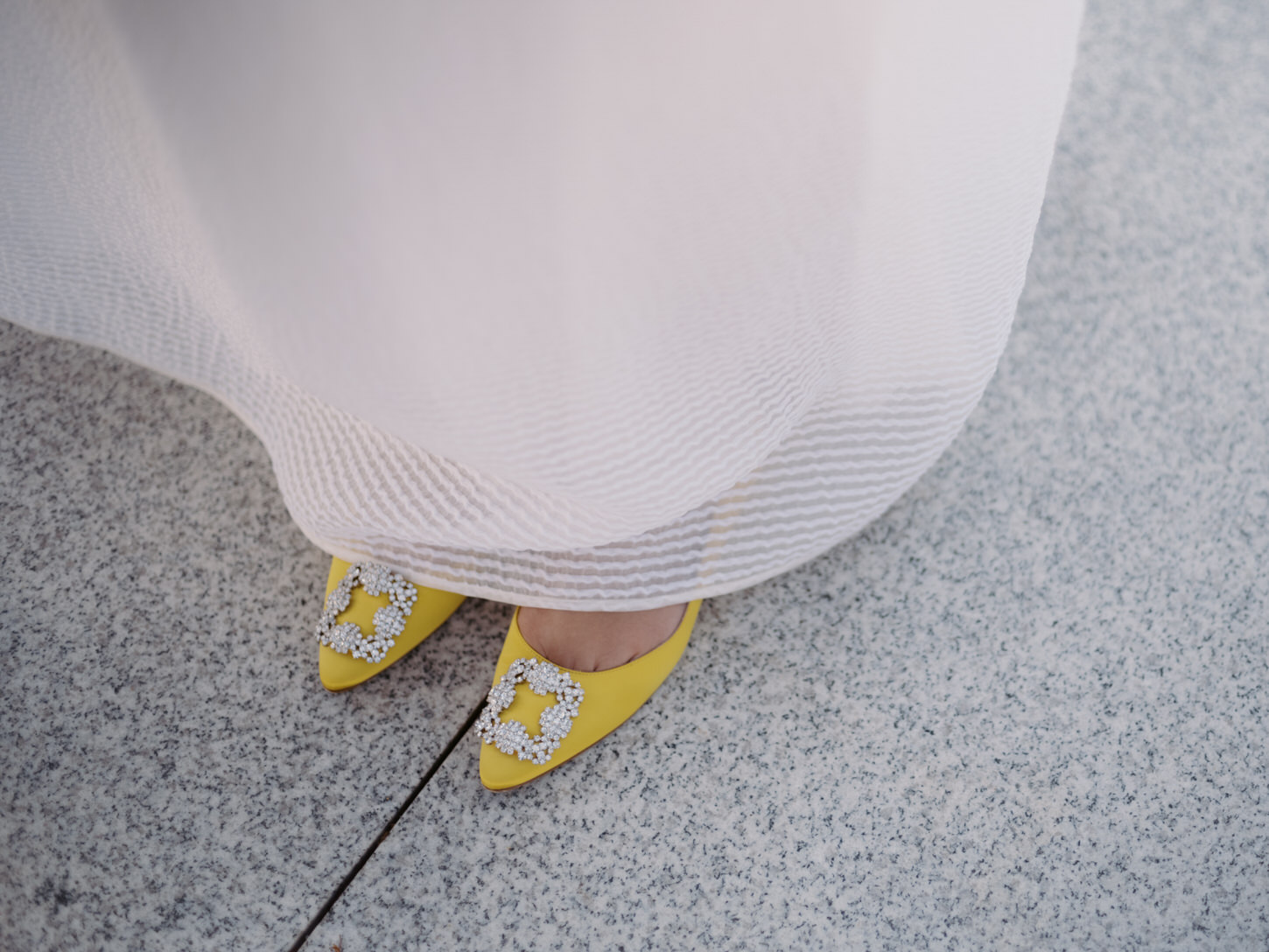 The chic elopement bride is wearing yellow shoes and white wedding dress, captured by Jenny Fu Studio.