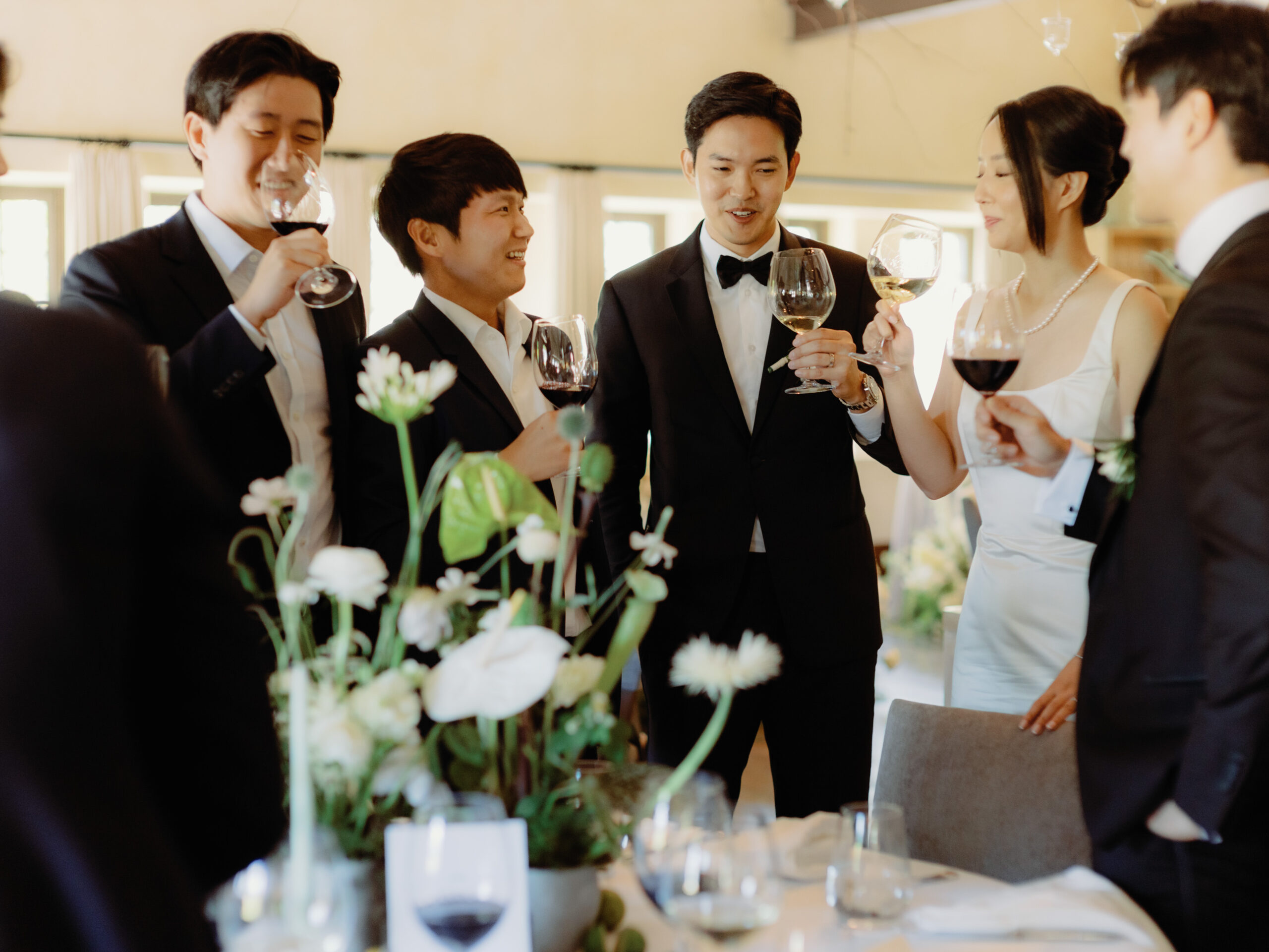 A perfect candid photo of the newlyweds having a toast with the groomsmen captured by Jenny Fu Studio.