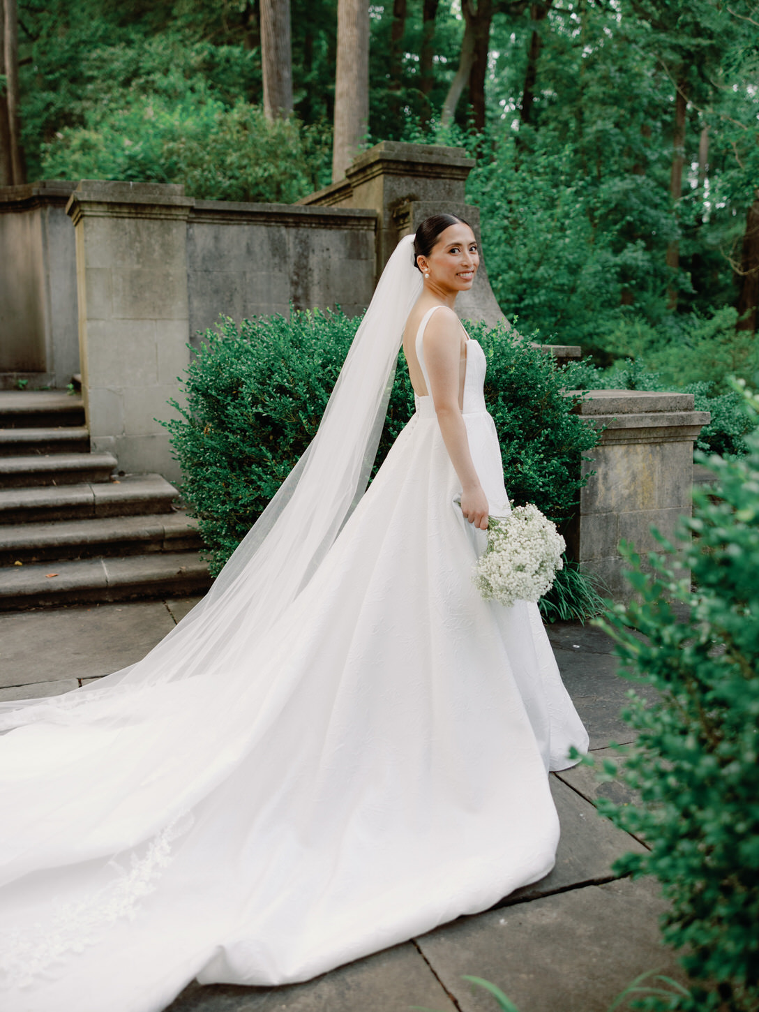 A portrait of the bride with lush greenery in the background, captured  by Jenny Fu Studio for a luxury wedding album.