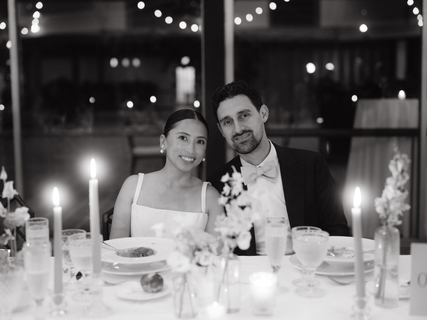 Editorial photo of the newlyweds sitting on the dining table in their wedding reception, shot  by Jenny Fu Studio.