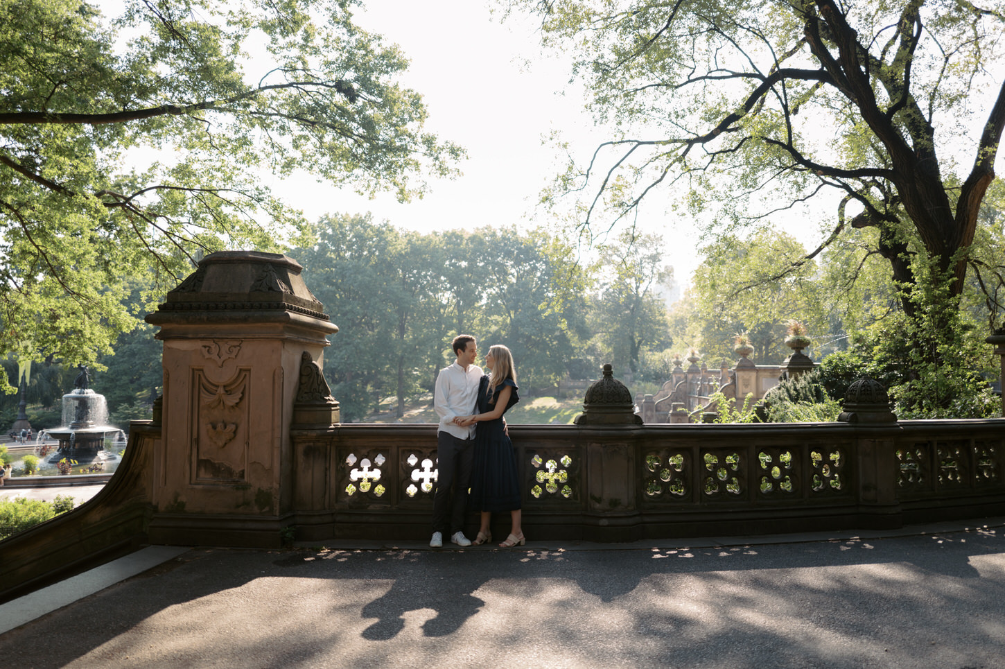 The engaged couple are talking intimately on a bridge in Central Park, New York City, captured by Jenny Fu Studio.