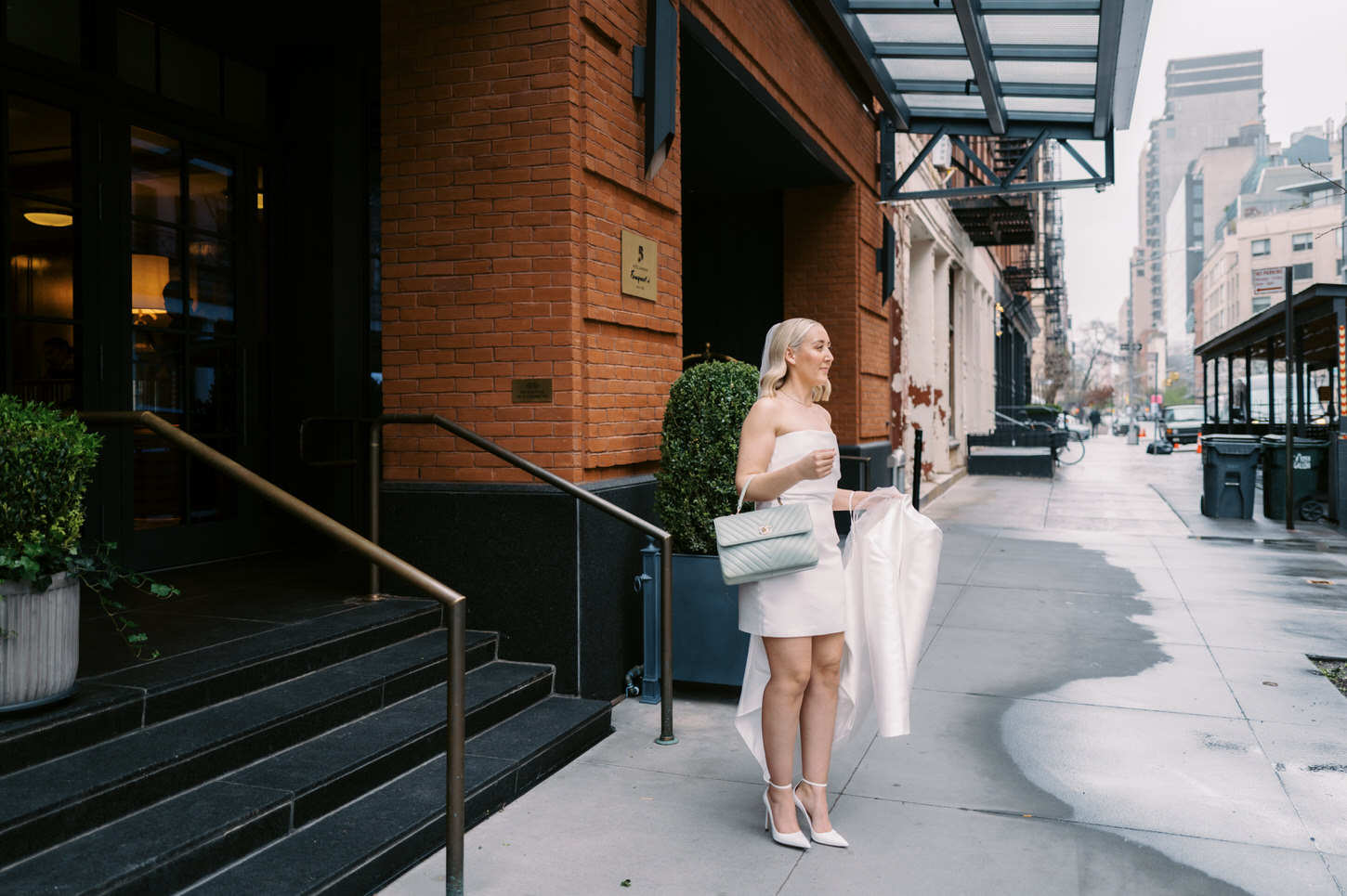 The bride is waiting for her groom outside of the hotel for their intimate elopement ceremony, captured by Jenny Fu Studio.