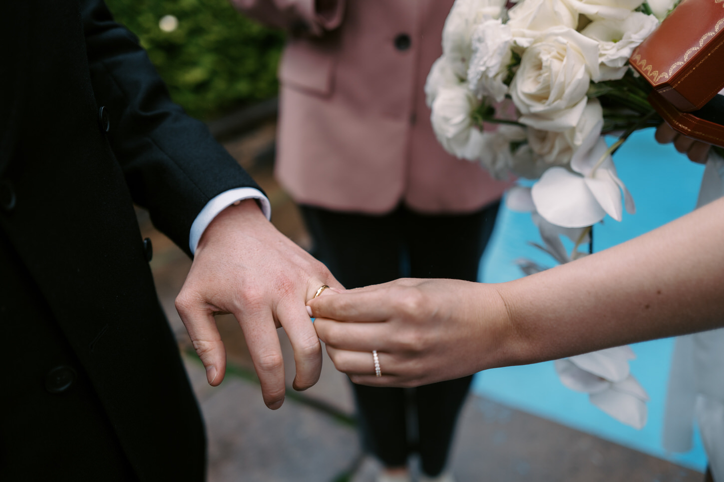 The bride puts on the wedding band on the groom's finger in their intimate elopement ceremony at 620 Loft and Garden, NYC, captured by Jenny Fu Studio.