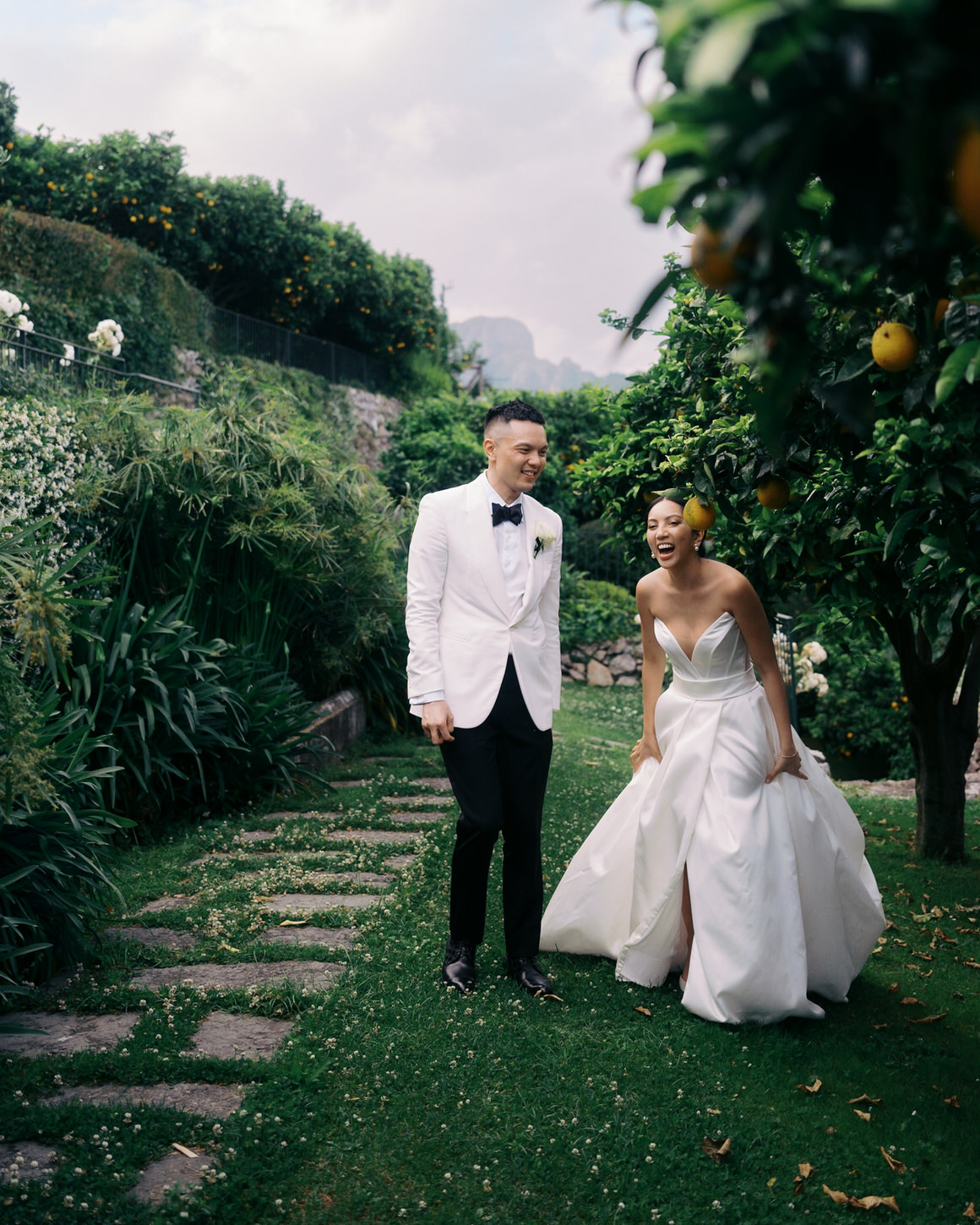 The bride and groom are having a fun, intimate time in the garden at Amalfi Coast, Italy, captured by Jenny Fu Studio.