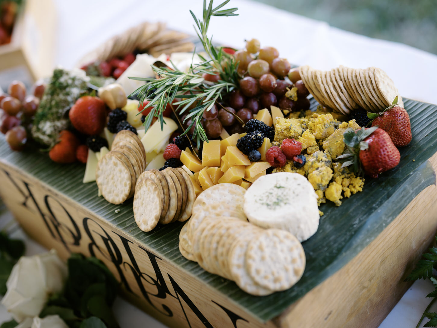 A charcuterie board filled with cheeses, biscuits and fruits perfectly captured for a wedding shower photo shoot by Jenny Fu Studio.