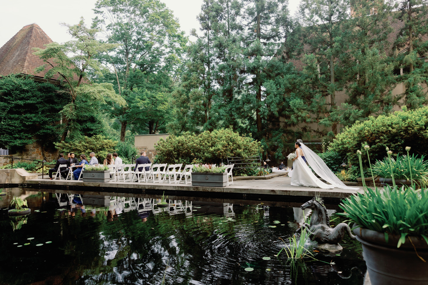 The bride is walking in the aisle as the guests watch her, captured by Jenny Fu Studio.