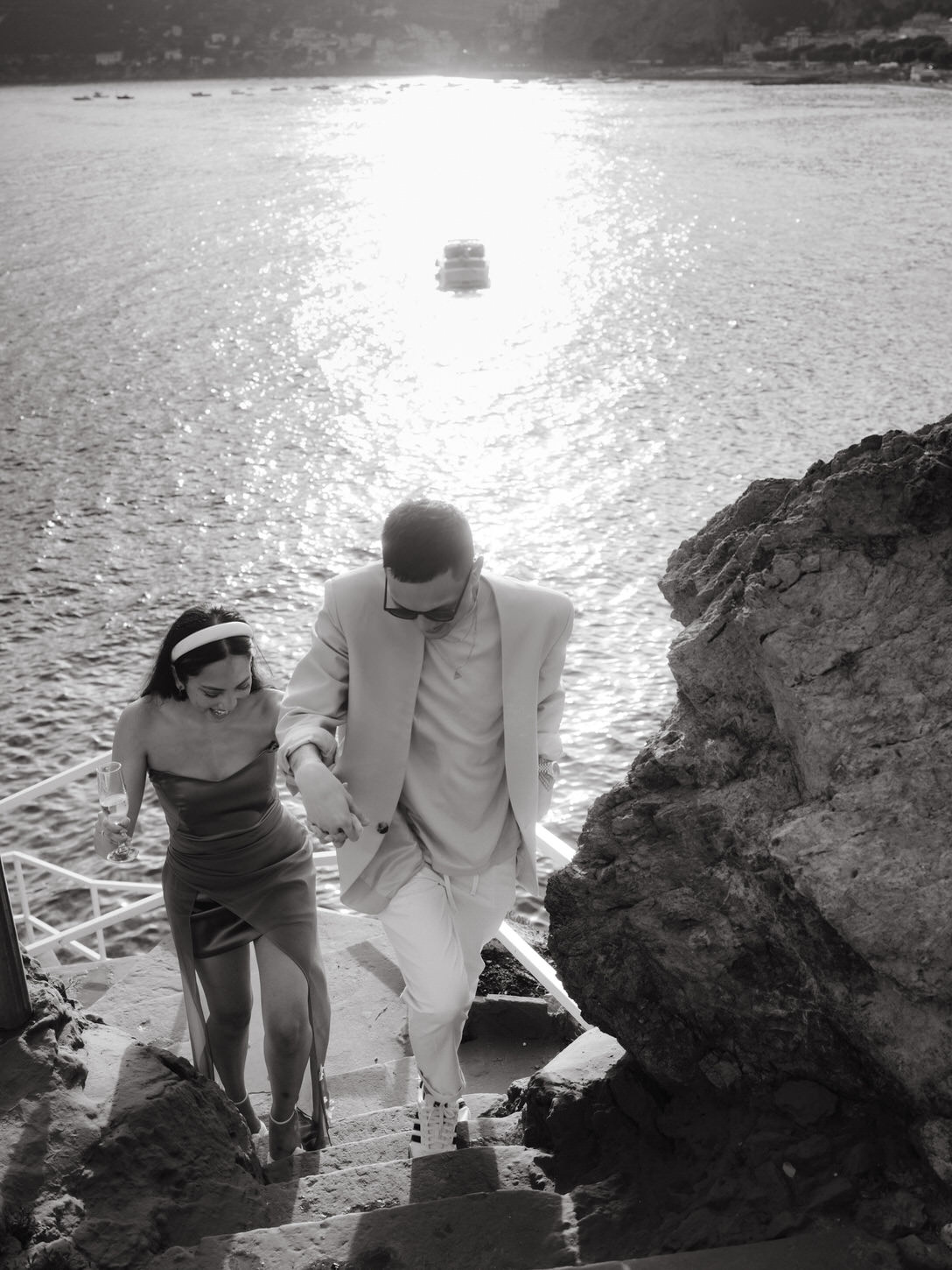 Black and white image of a couple with the Amalfi Coast in the background captured by Jenny Fu Studio for a destination wedding.