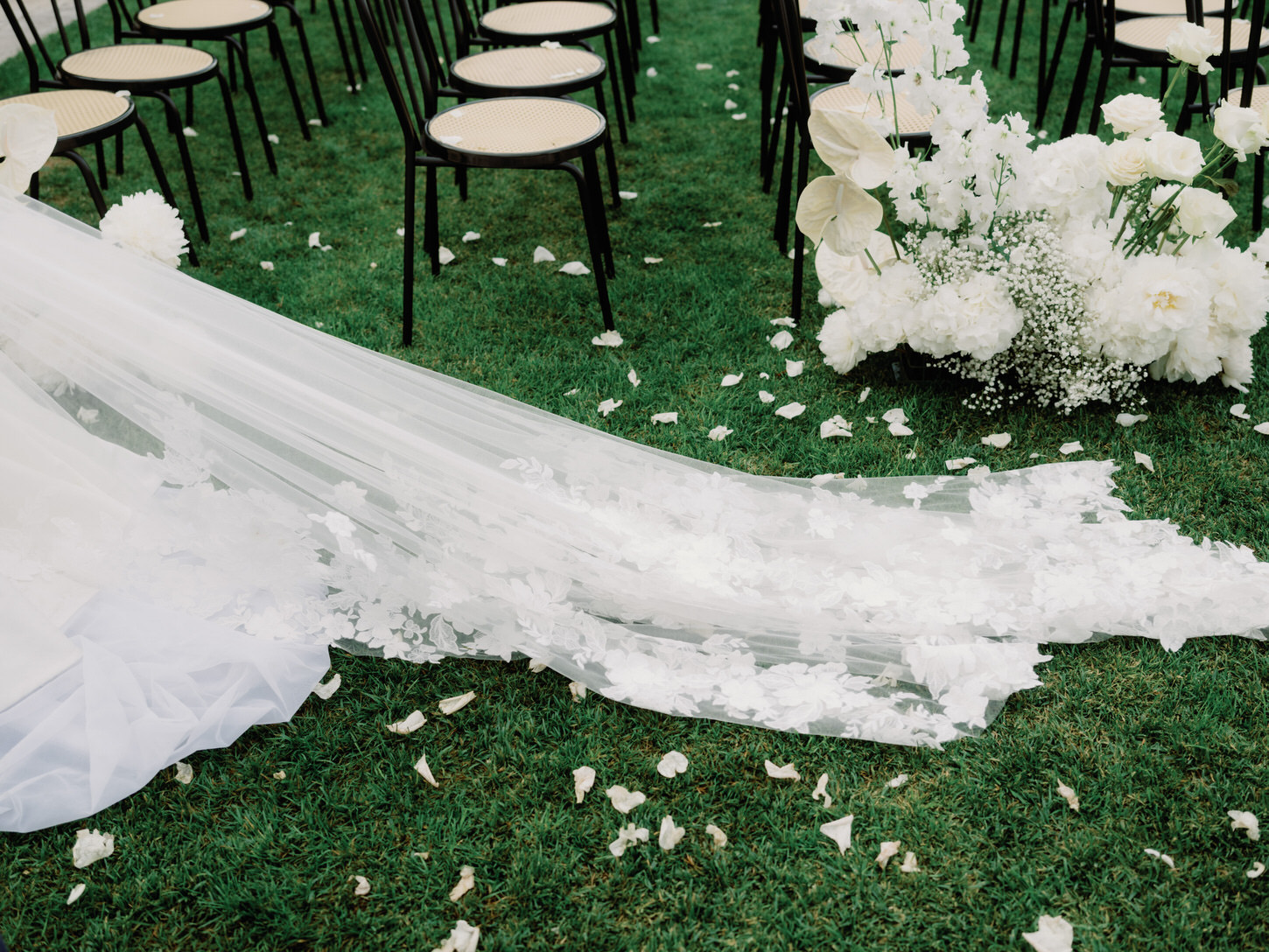 The bride's veil is lying on the grass captured by Jenny Fu Studio for a destination wedding.