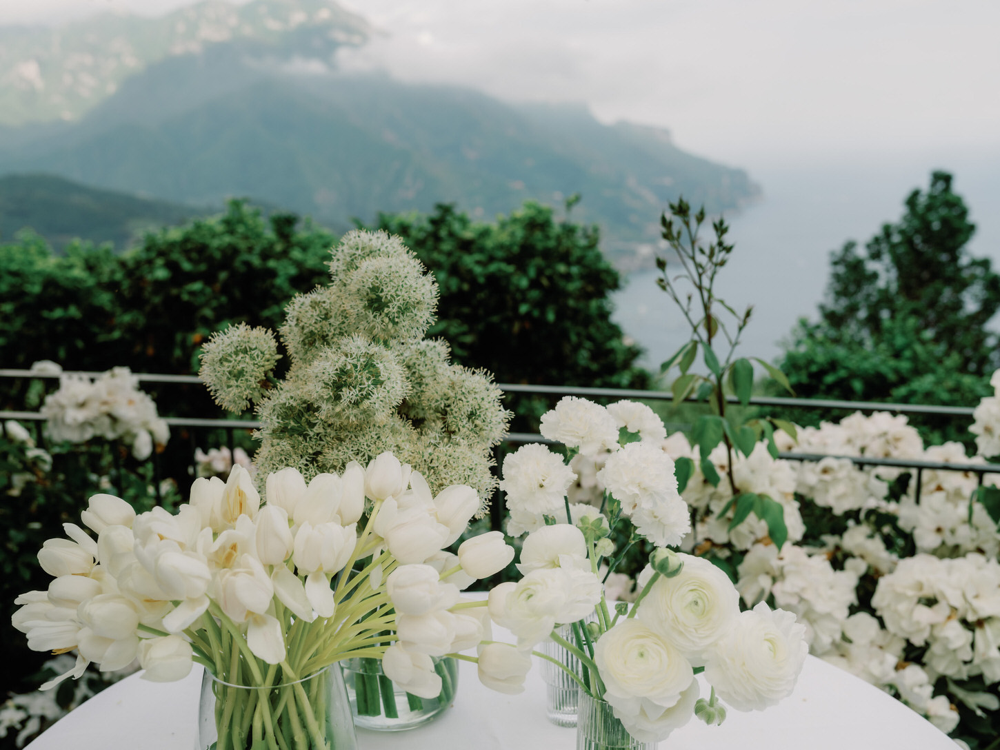 Beautiful white flowers inside glass jars captured by Jenny Fu Studio for a destination wedding.