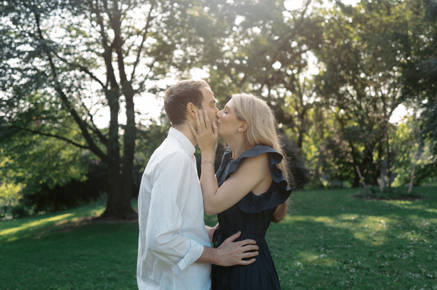 The engaged couple are giving each other a sweet kiss in Central Park, NYC, captured by Jenny Fu Studio.