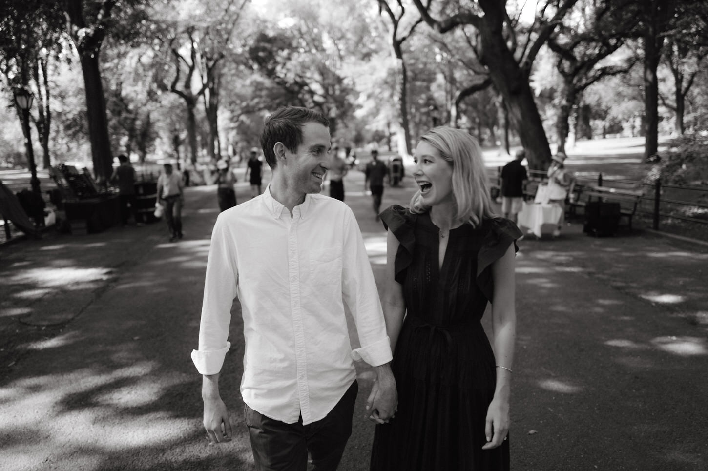 Black and white photo of the engaged couple having a good conversation while walking in Central Park, New York, captured by Jenny Fu Studio.