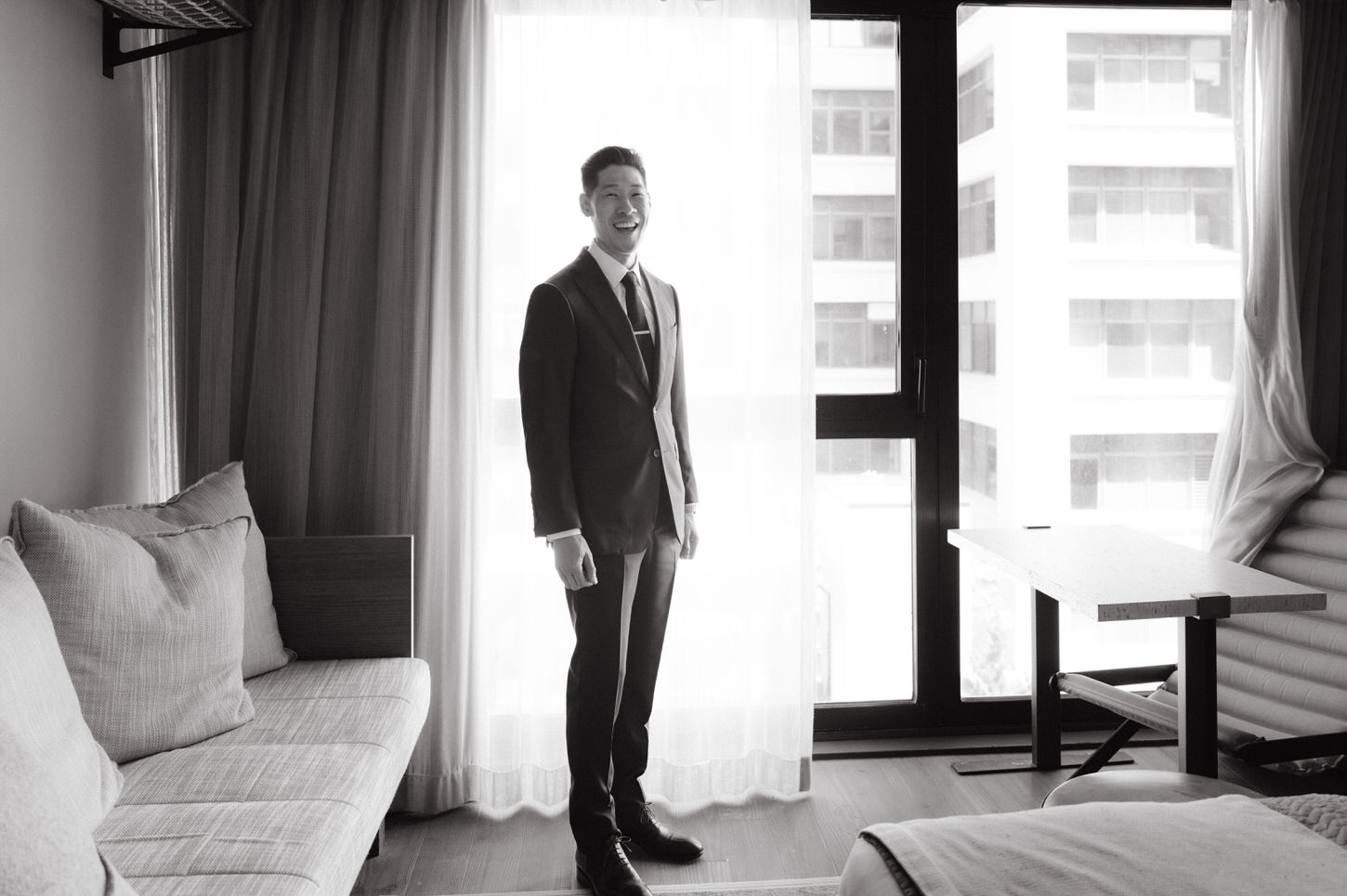 Black and white getting ready image of the groom inside a hotel room, captured by Jenny Fu Studio.