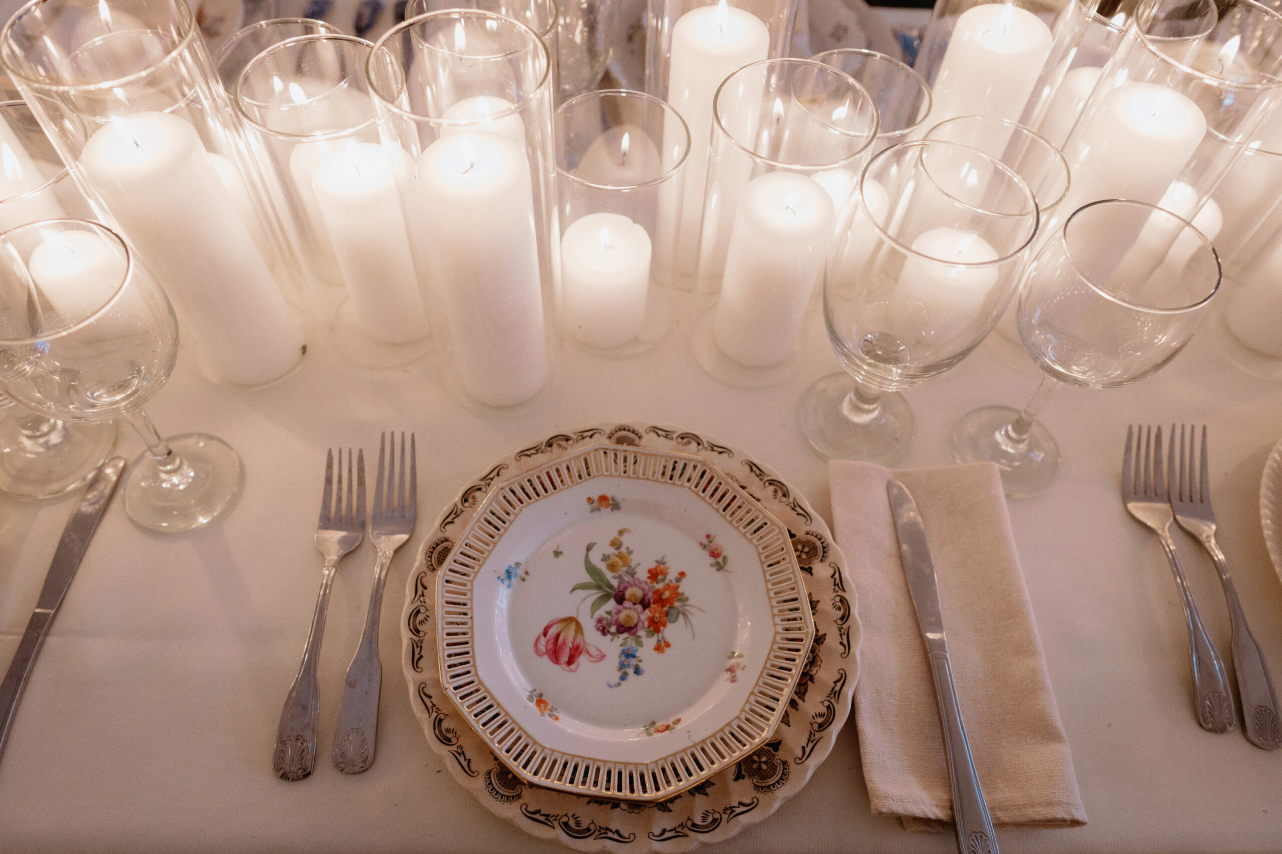 A wedding reception dinner set up with lots of white candles as table centerpieces, captured by Jenny Fu Studio.