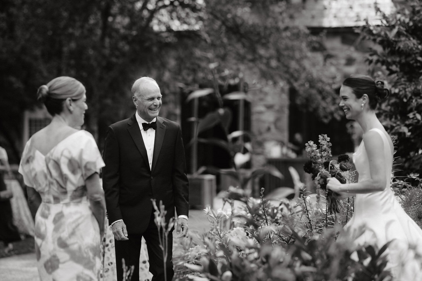 Black and white photojournalistic image of the bride walking towards her parents before walking down the aisle captured by Jenny Fu Studio.