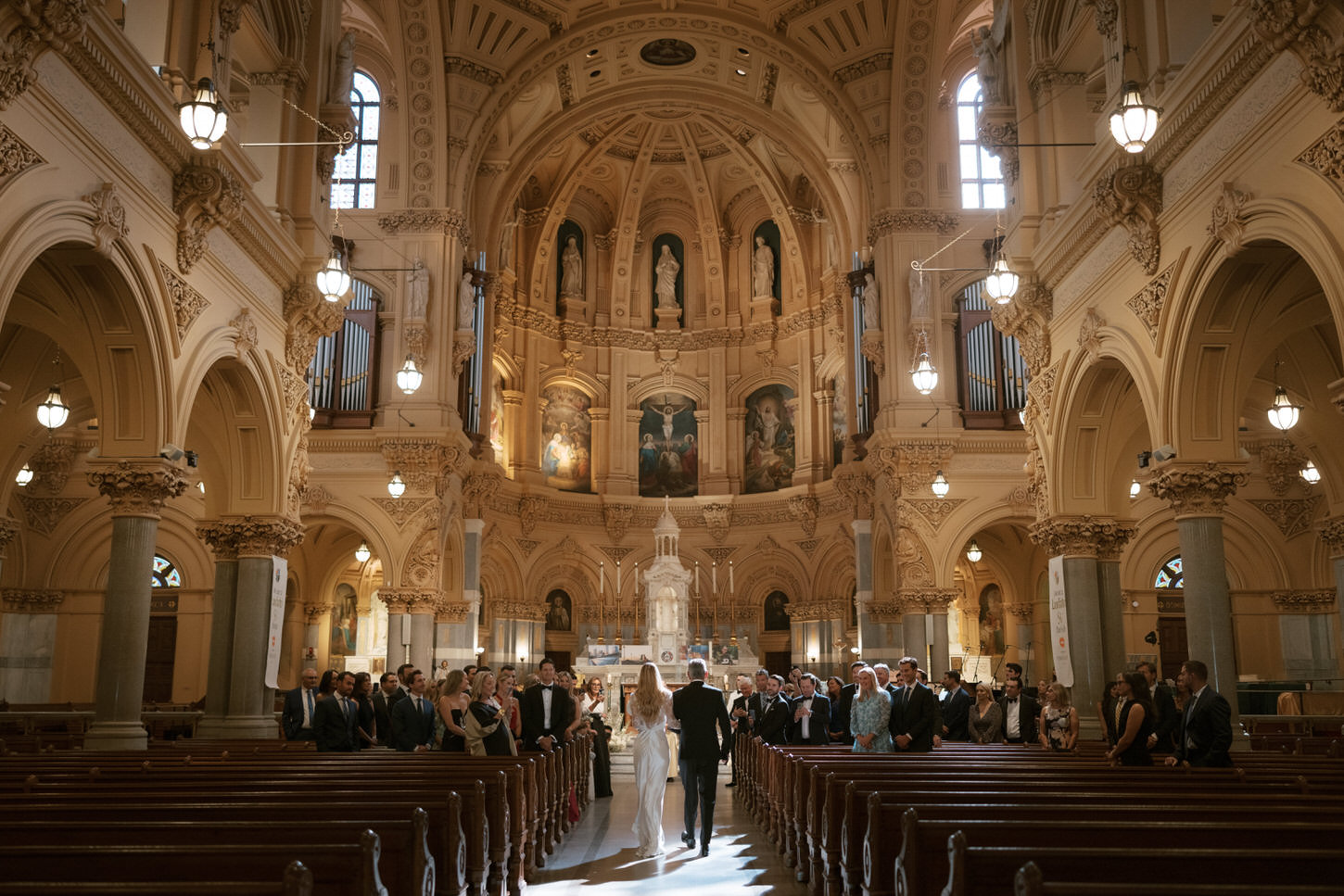 The bride and groom walks in the aisle as guests watch on, captured by Jenny Fu Studio.