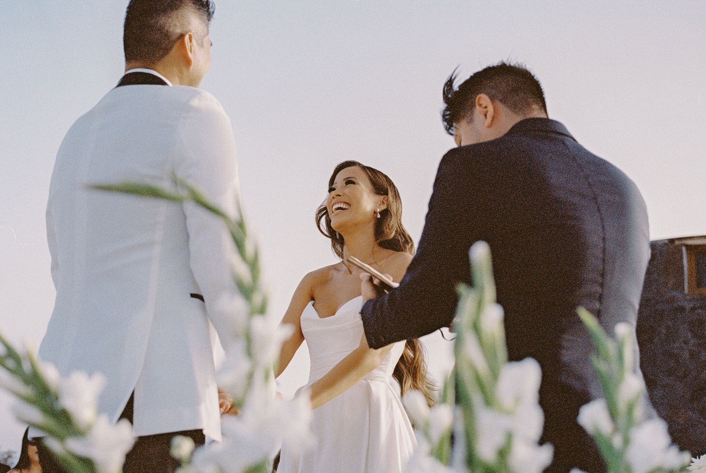 The bride is stunningly smiling at her groom in the destination wedding ceremony, candidly captured by Jenny Fu Studio.  