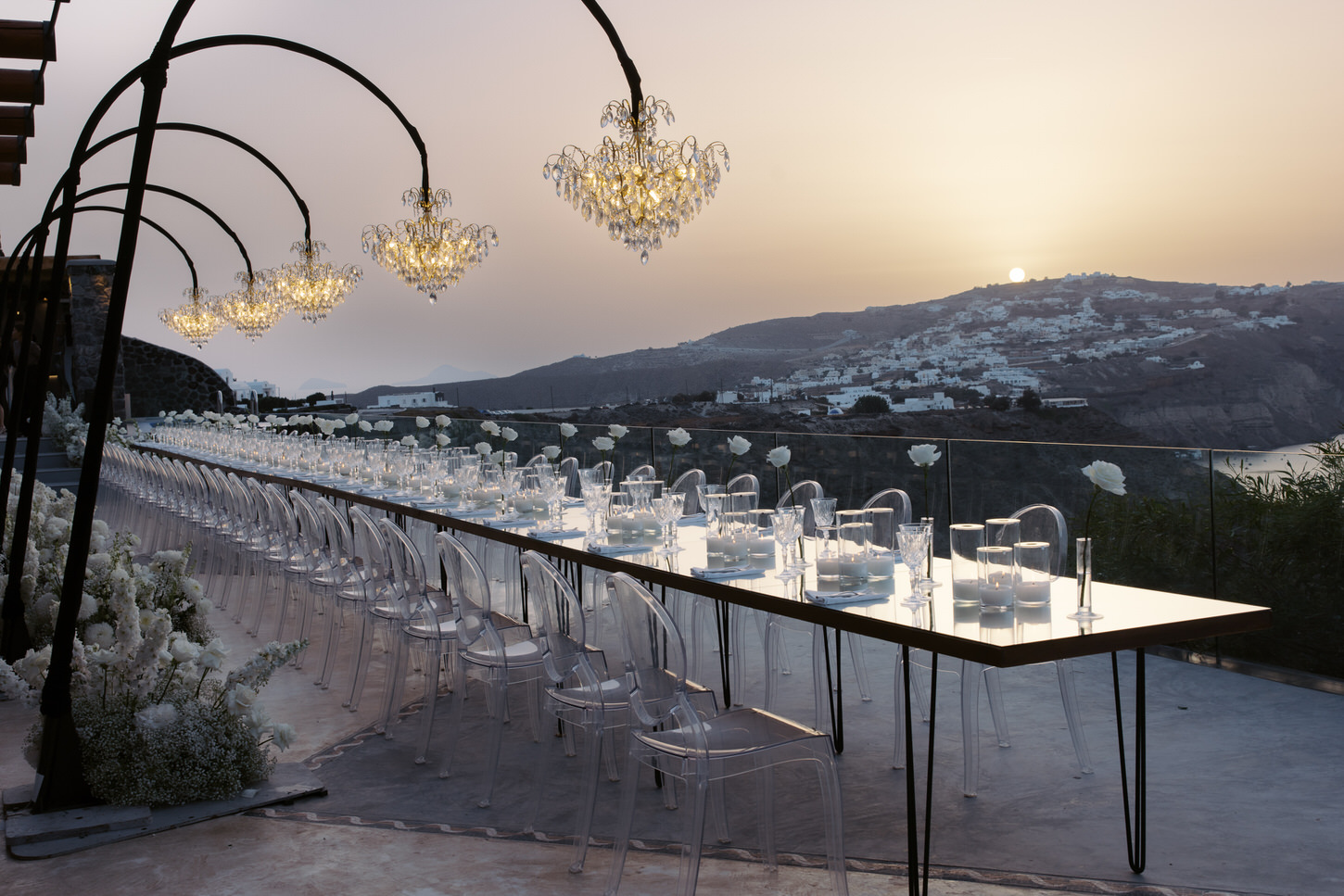 The wedding reception dinner set-up with a gorgeous mountain view in Santorini, Greece, captured by Jenny Fu Studio.