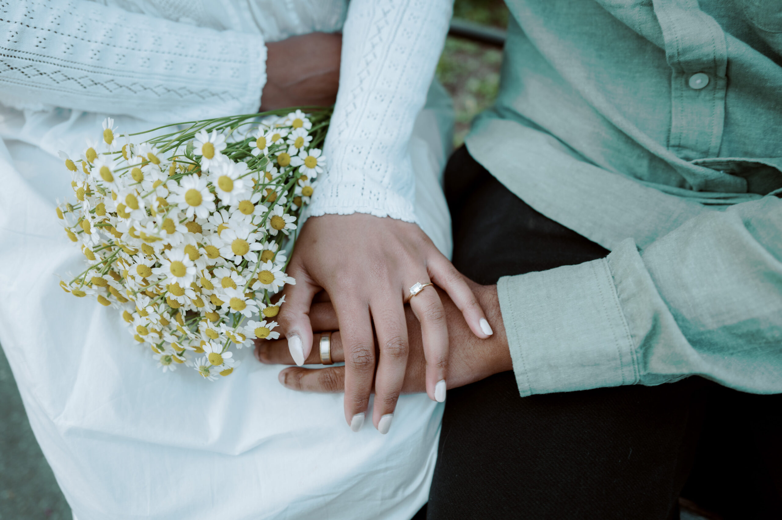 Close-up photo of the engagement ring worn by the bride, with a bouquet of fresh spring flowers, captured by Jenny Fu Studio.