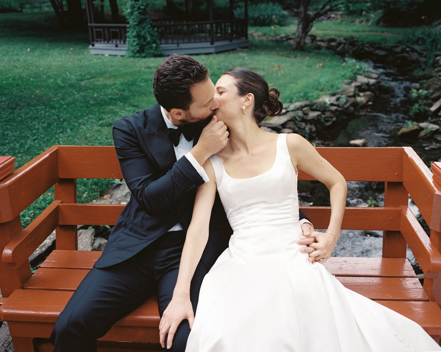 The newlyweds lovingly kiss each other in an Upstate NY exclusive wedding venue, candidly captured by Jenny Fu Studio.