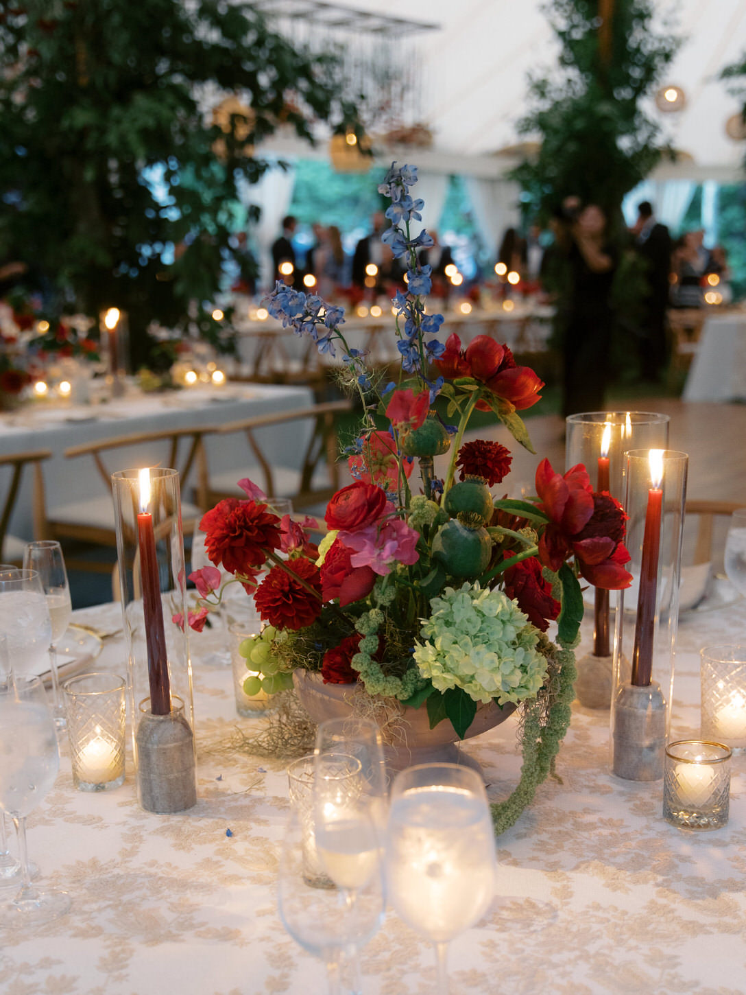 Beautiful wedding reception details with red and white flower centerpiece and candles of different shapes, captured by Jenny Fu Studio.